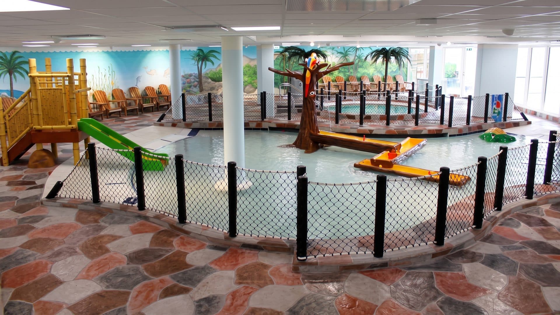 The childrens play area of Lalandia with its climbing structure and tree above shallow water