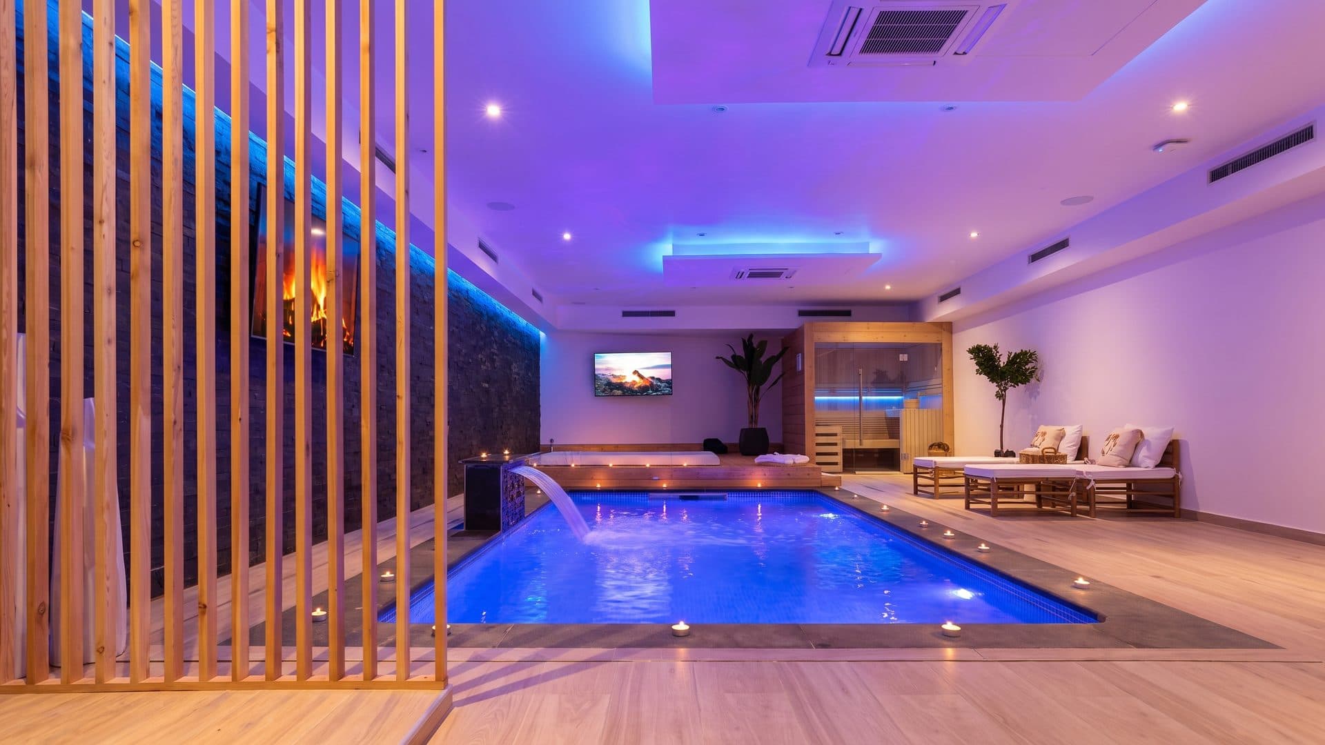 The spa pool of Le Jasmin behind its slatted screen under coloured light