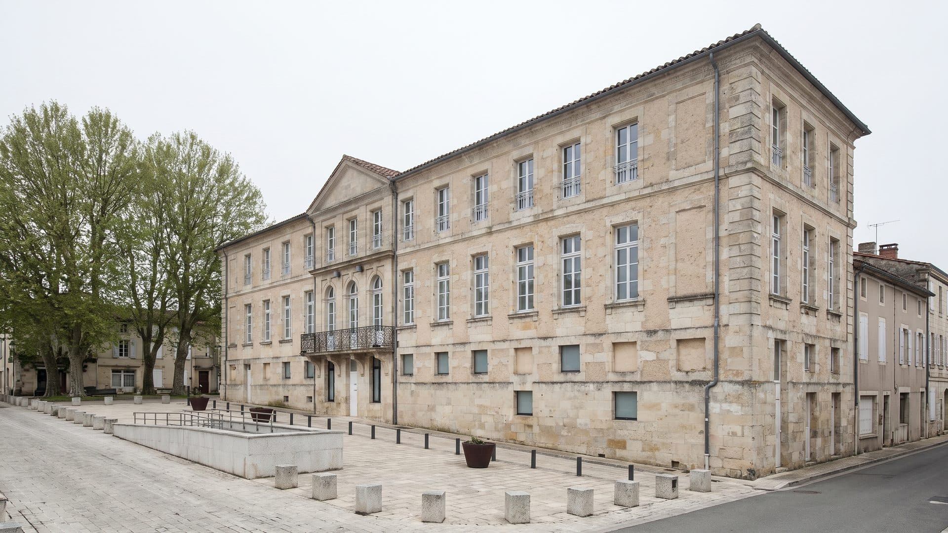 The pale stone spa building of Lectoure seen three-quarters on with its terrace