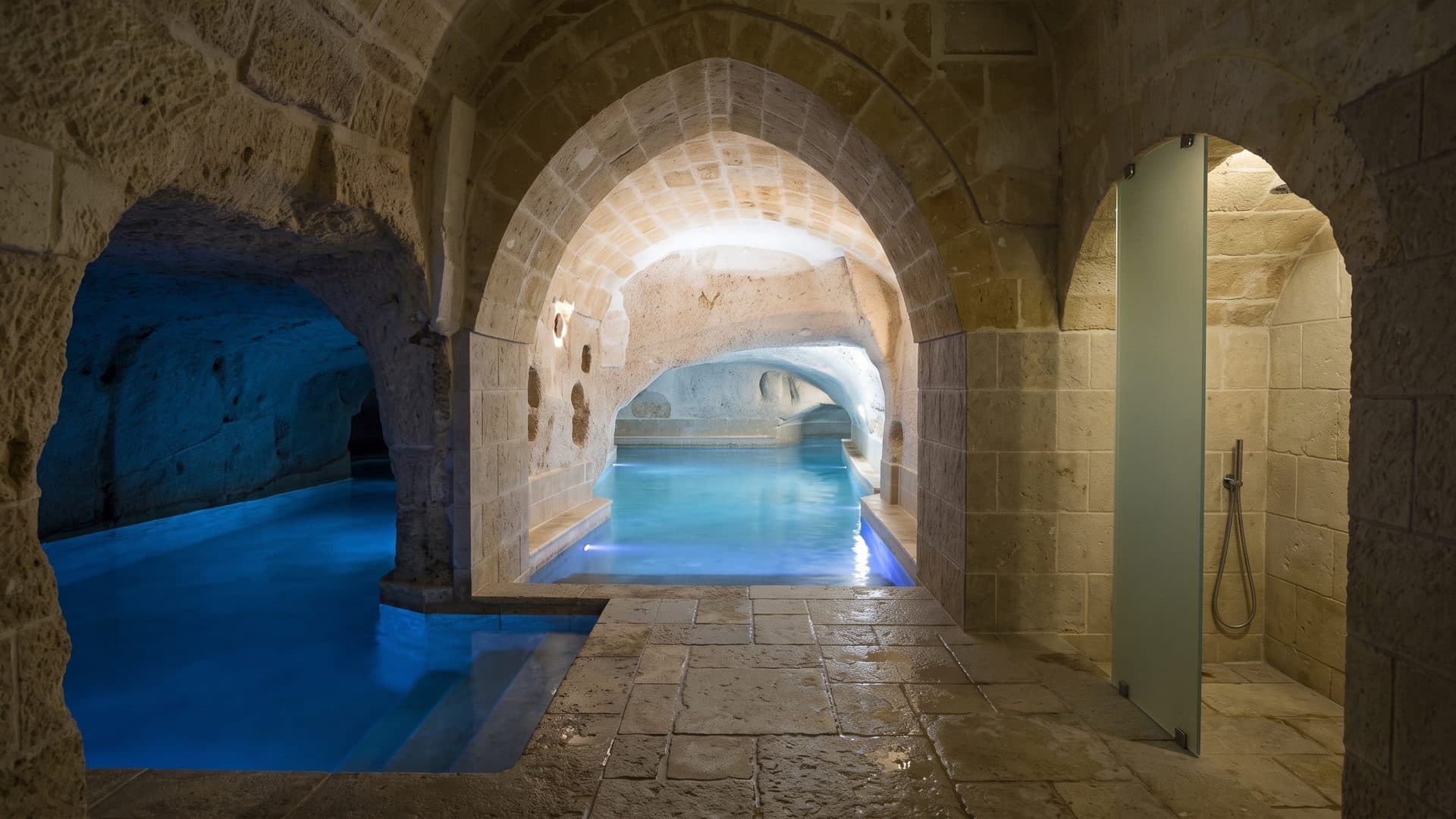 The cave-like pool of the Locanda di San Martino in Matera carved into the tufa rock under stone arches