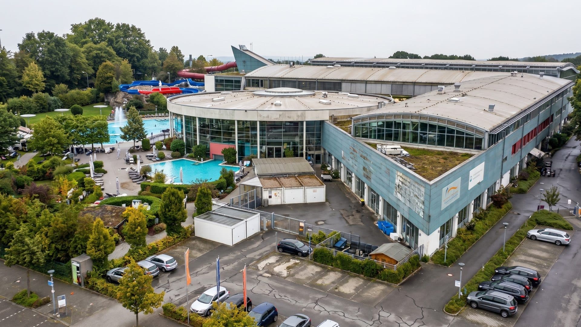 The leisure bath complex from above, with its round glazed pool hall, outdoor pools and slide tower
