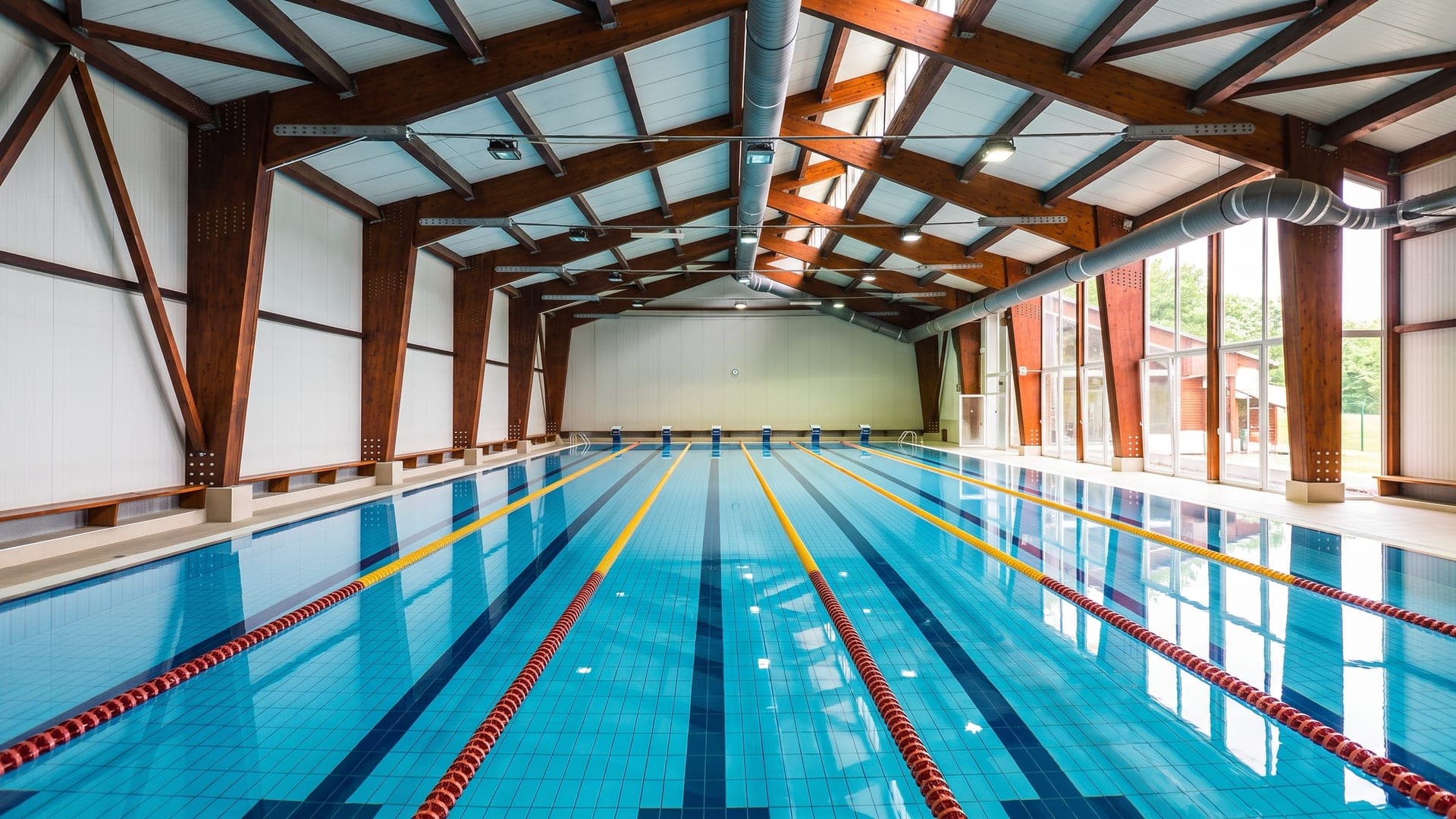 The indoor lane pool at the Mohacs swimming baths, under exposed timber roof trusses.