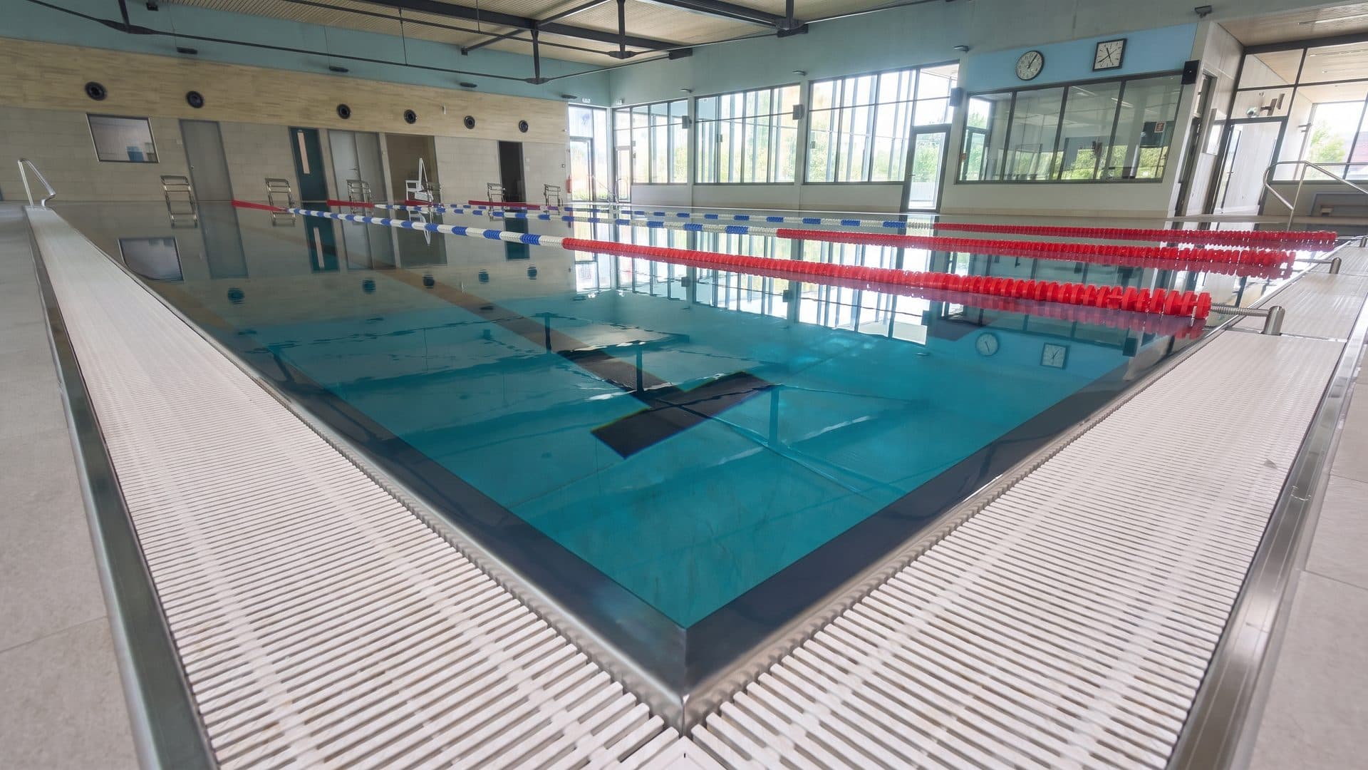 The indoor pool of the Moselbad with its lane ropes running under the hall roof