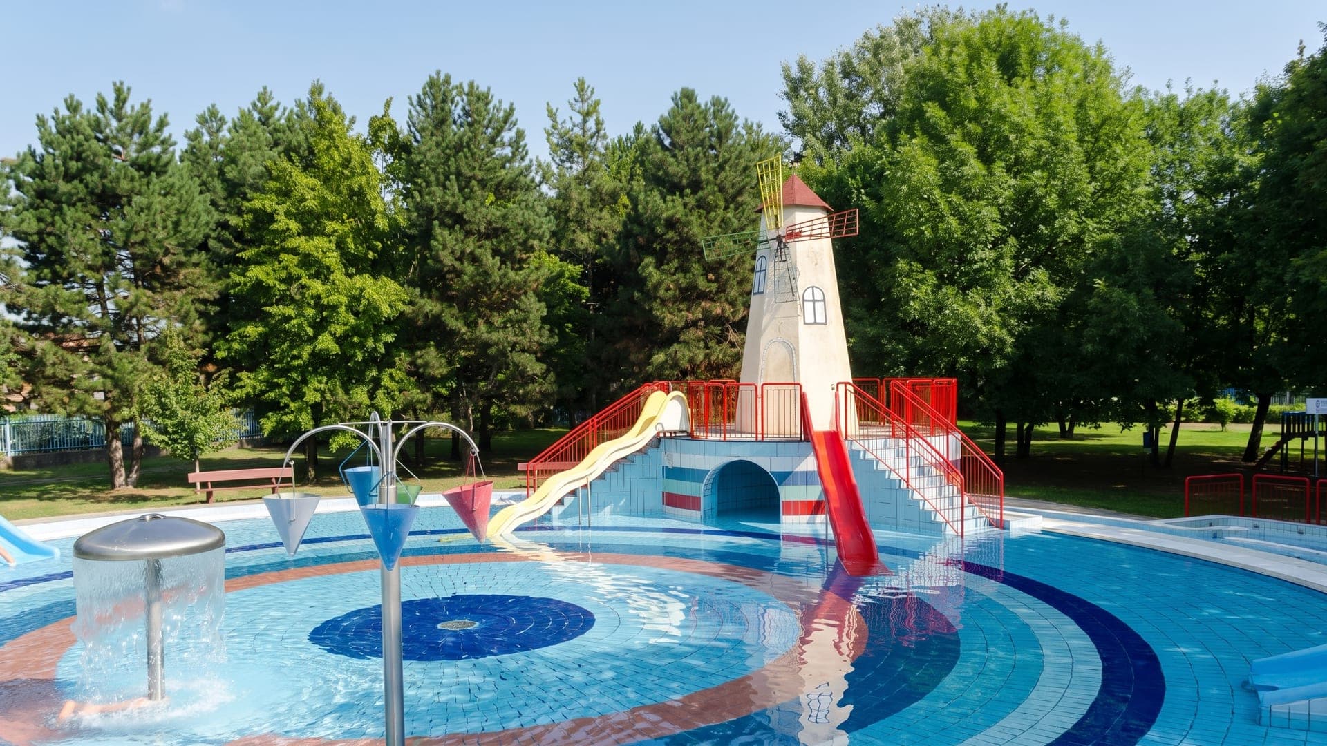 The children's pool at the bath in Nagykata, with a windmill-shaped slide tower and water sprays.