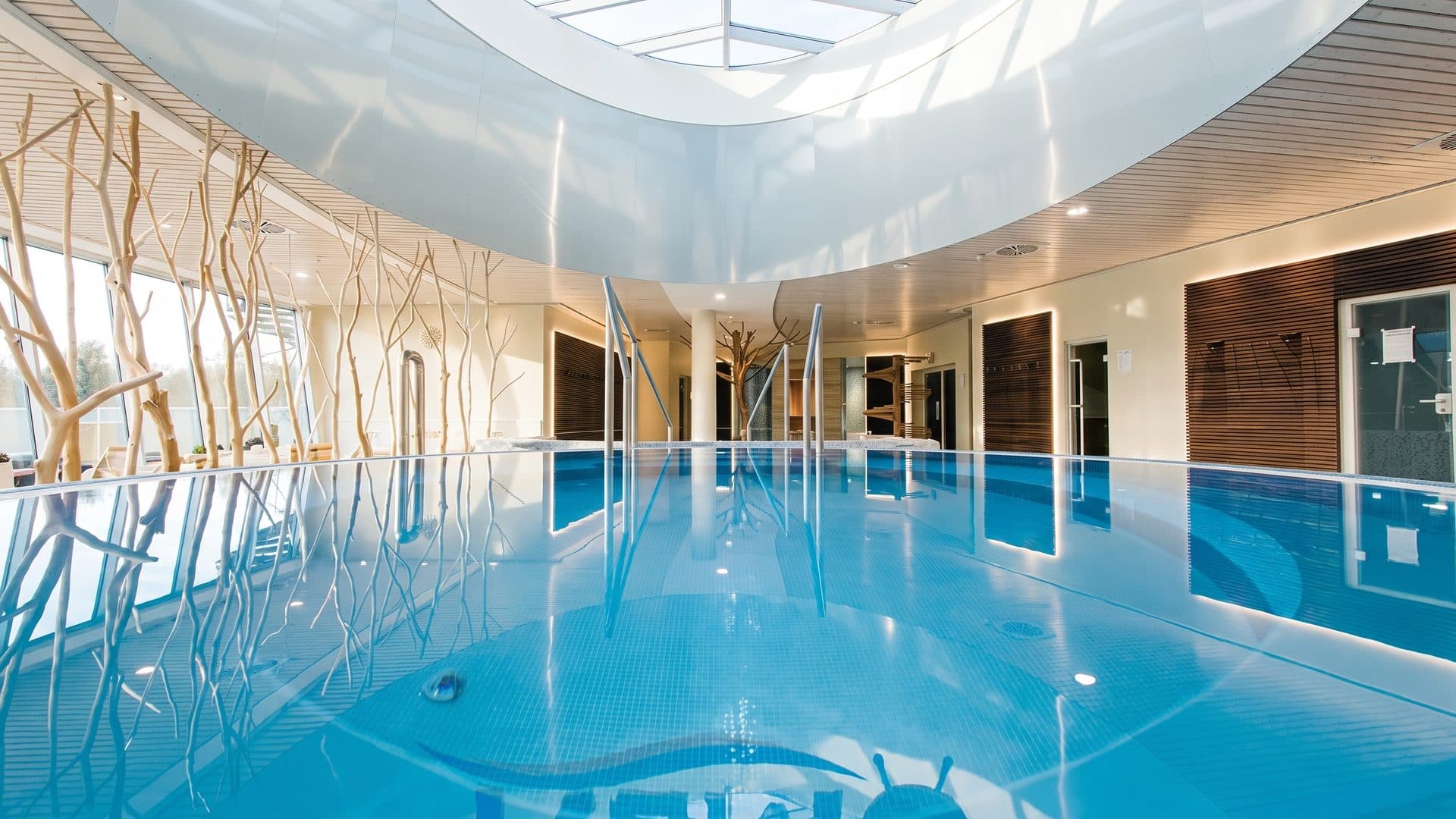 The pool hall of Nemo with its tree-shaped lamps and white columns under a daylit roof