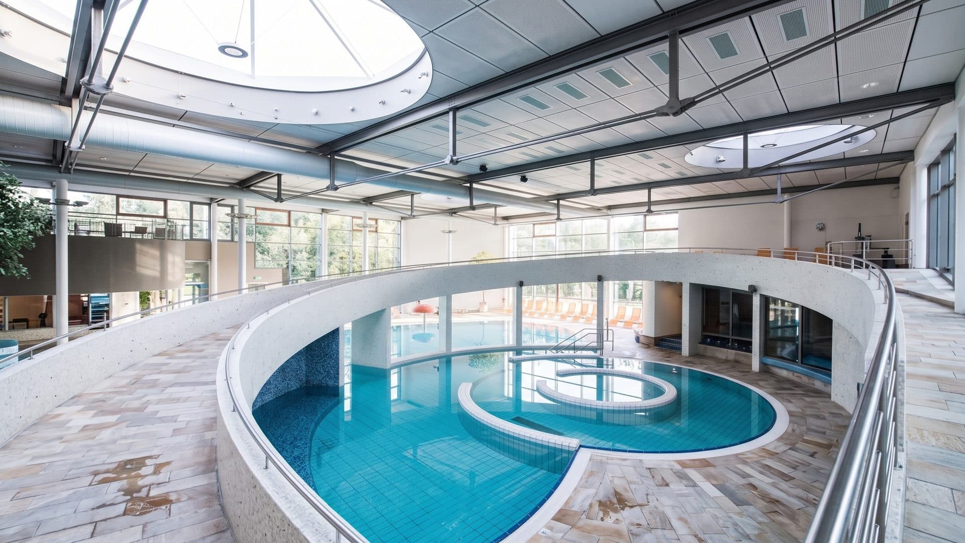 The indoor leisure pool of the Nettebad in Osnabruck with a round whirlpool, seen from the gallery under the skylight