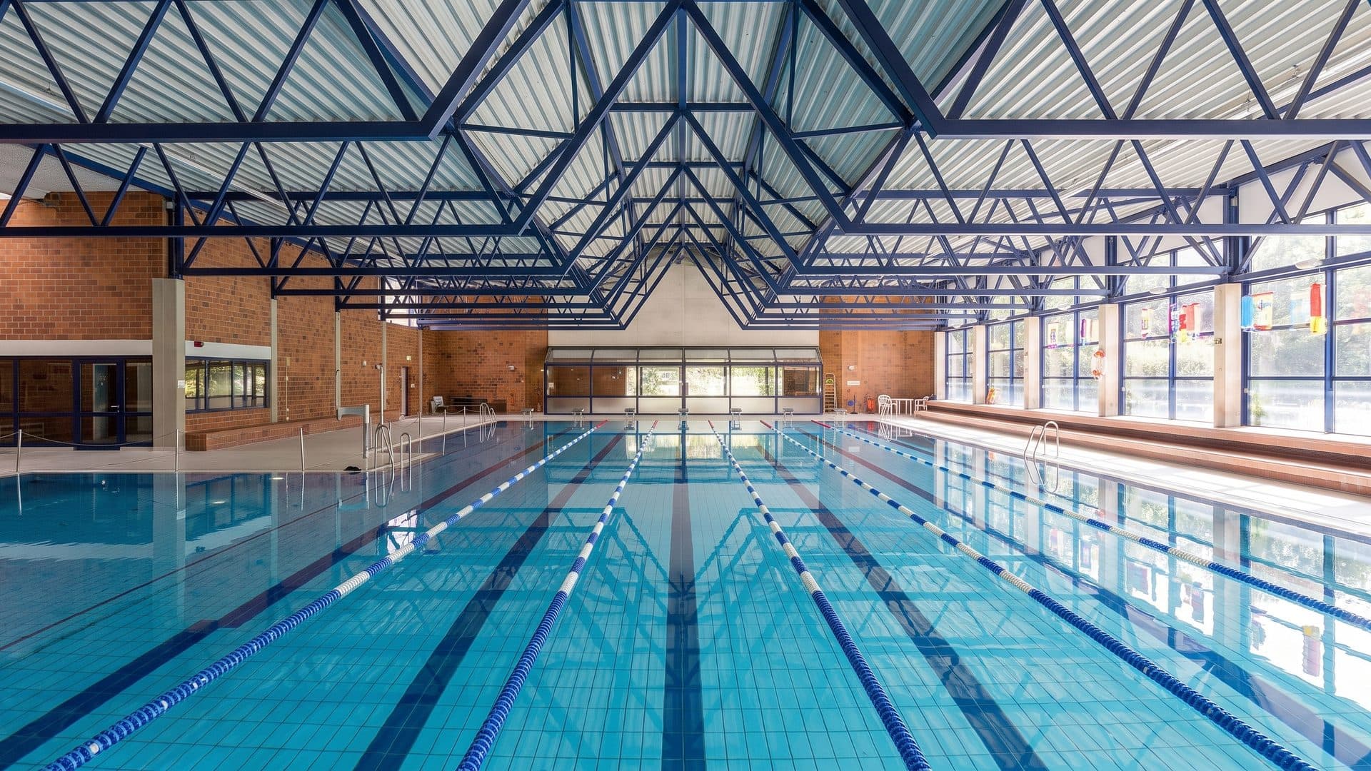 The fifty-metre pool of the Ossendorfbad seen down its length under the folded roof