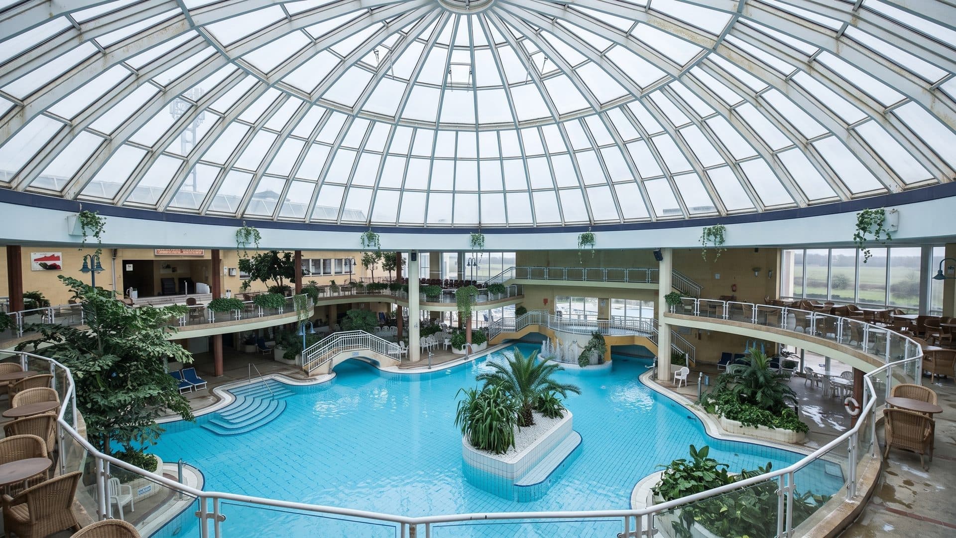 The leisure pool of the Ostseetherme under a large glass dome with a planted island and galleries