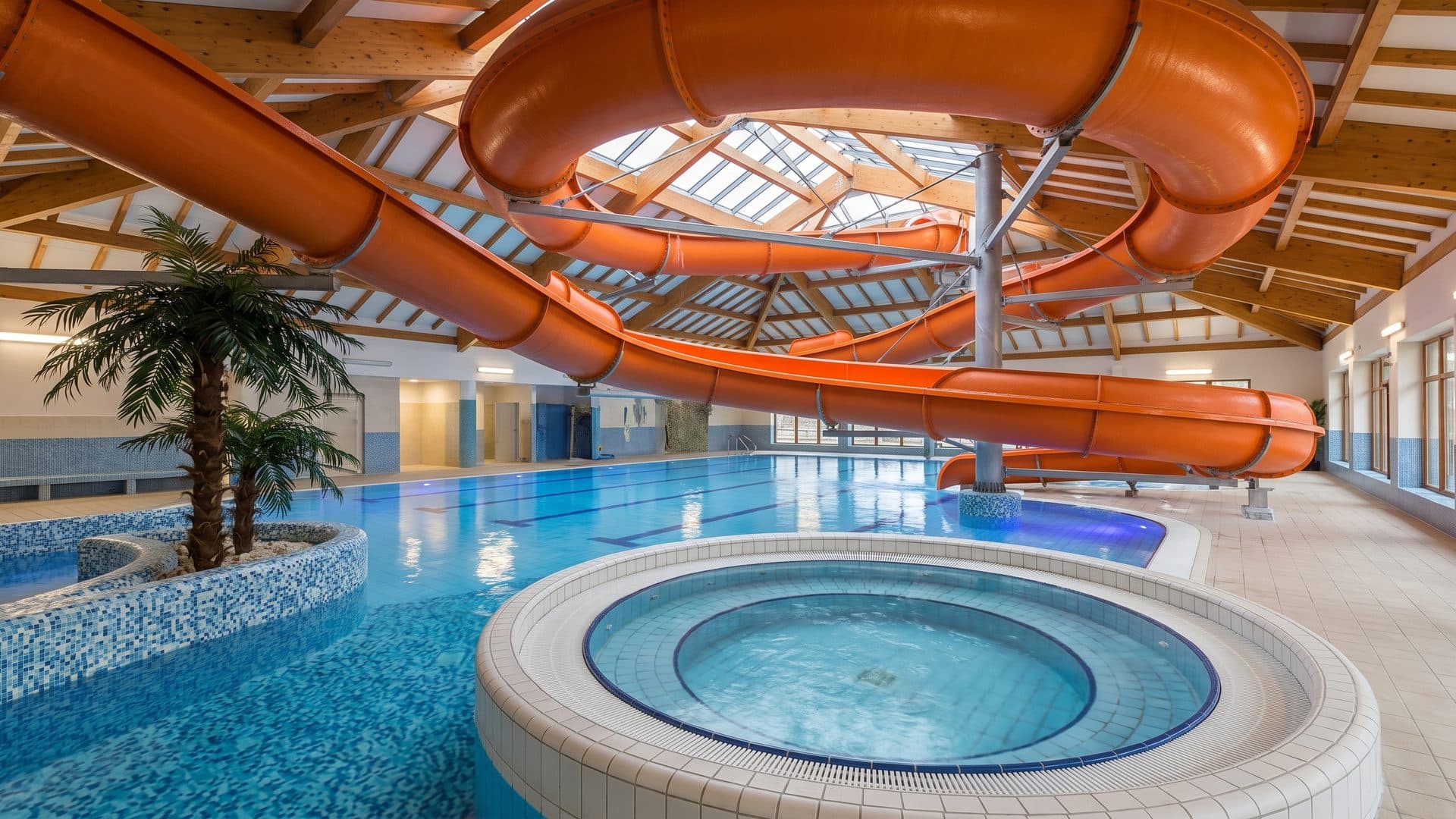 The hall of Park Wodny Olza with its slide tubes overhead and the pools below