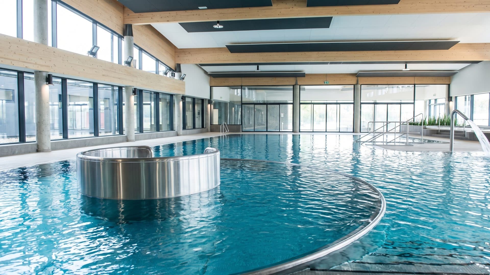 The recreation pool of the Qarium around its round water feature by the glazed wall
