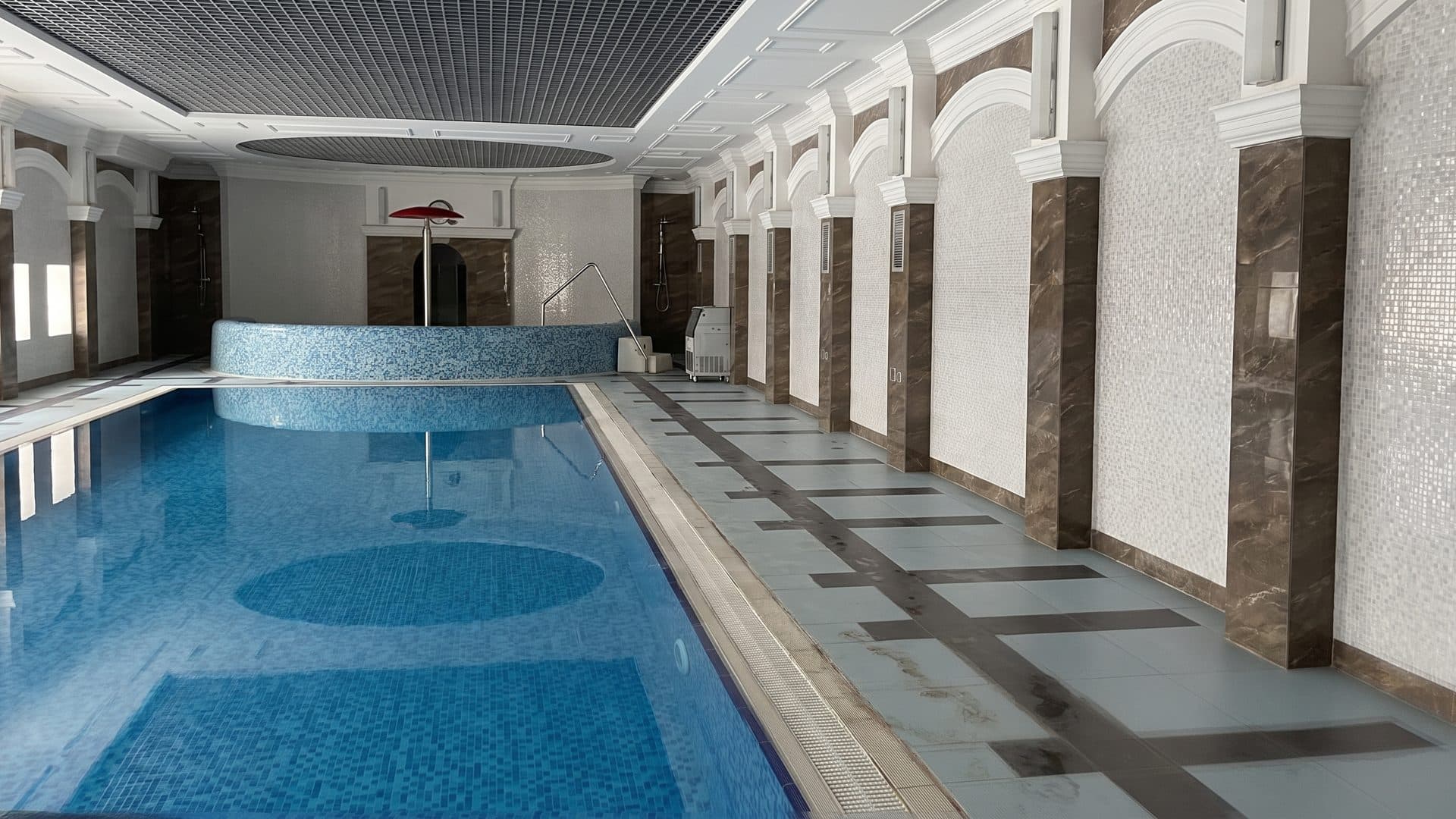 The indoor pool at the Radon sanatorium in Dyatlovo, its arched niches and dark stone piers along the water