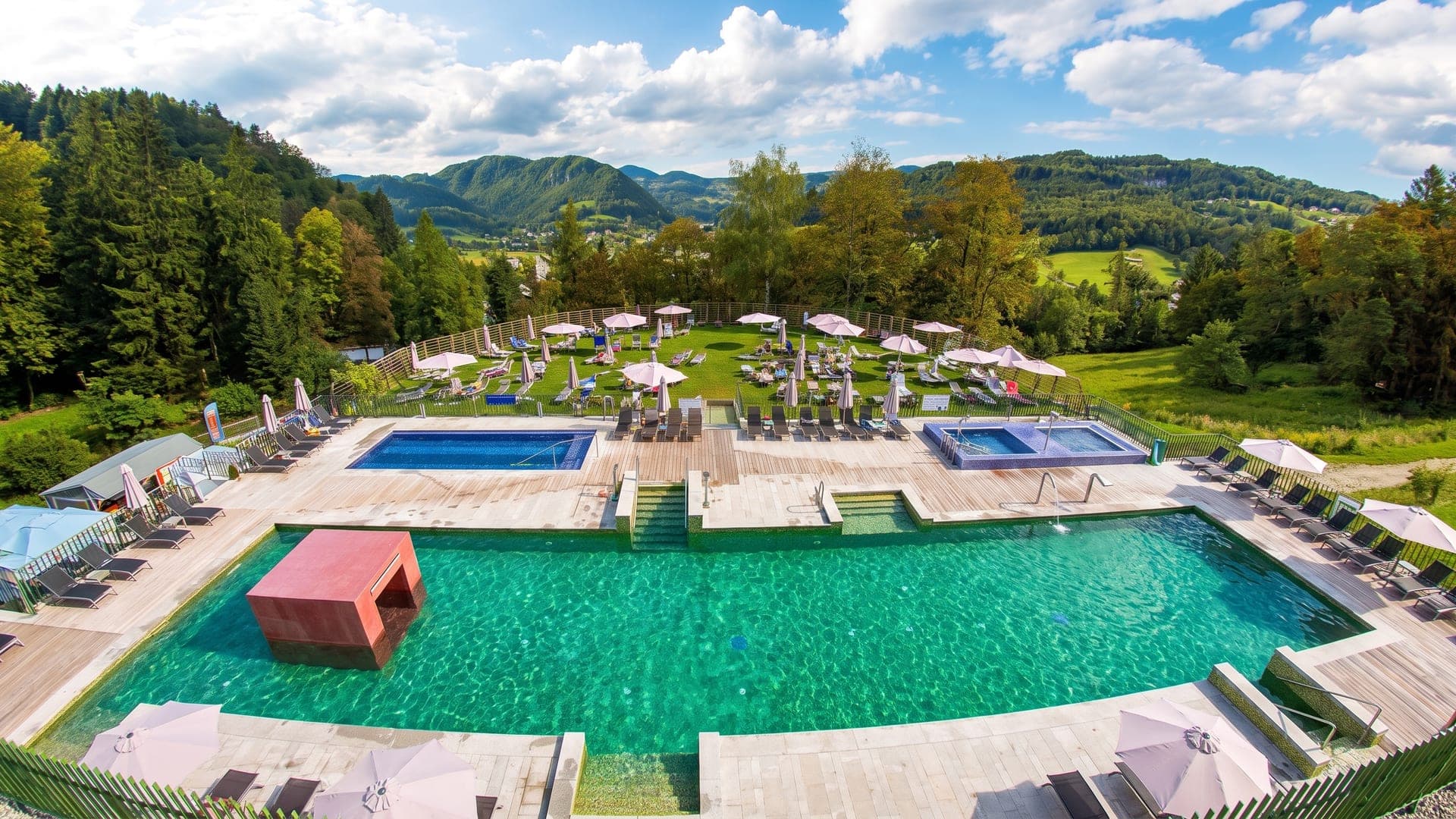The pools at Rimske Terme on their terrace above the wooded valley, with the hills of Styria behind.