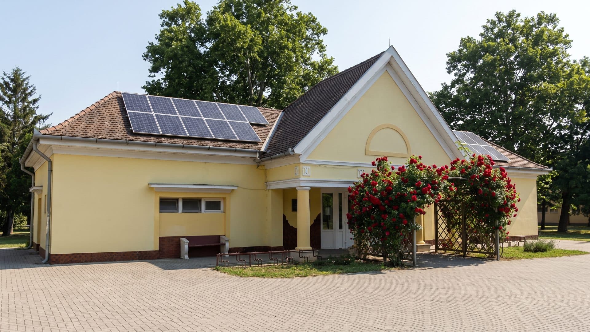 The yellow entrance pavilion of the Rózsa baths behind its climbing roses
