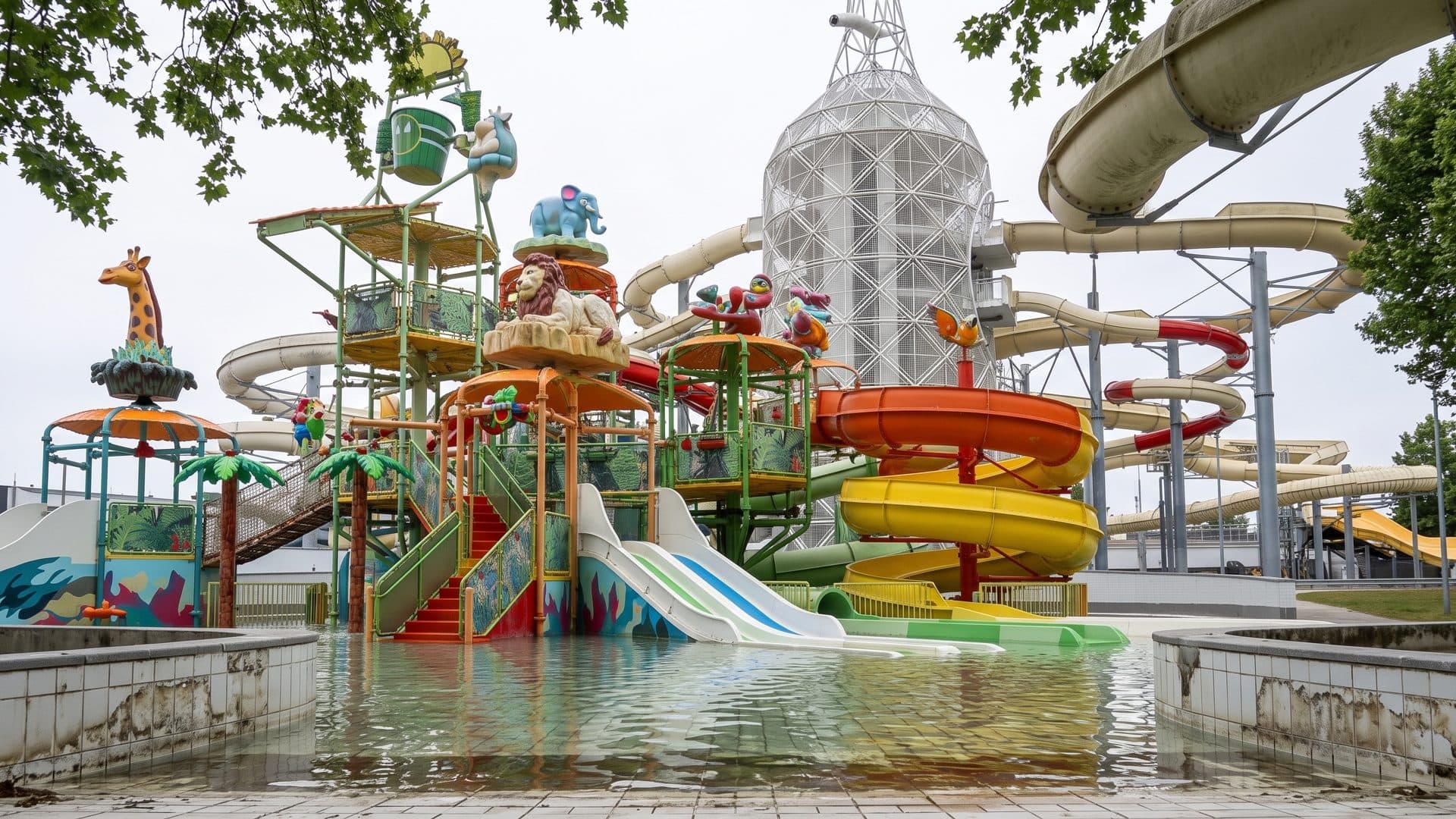 Slide tower of the water park with its coloured tubes and the latticed dome behind.