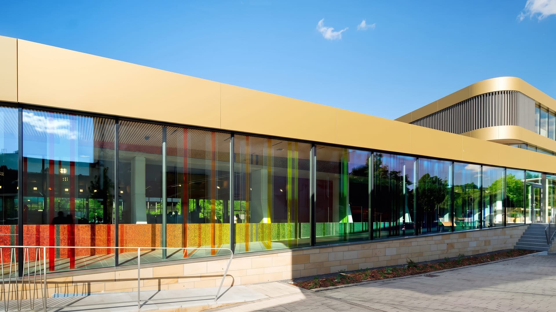 Modern glass-fronted building with a yellow roof