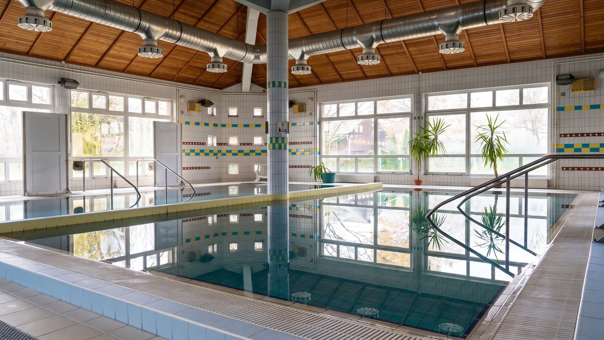The pool of the Sarret Kincse baths under its timber ceiling by the window wall