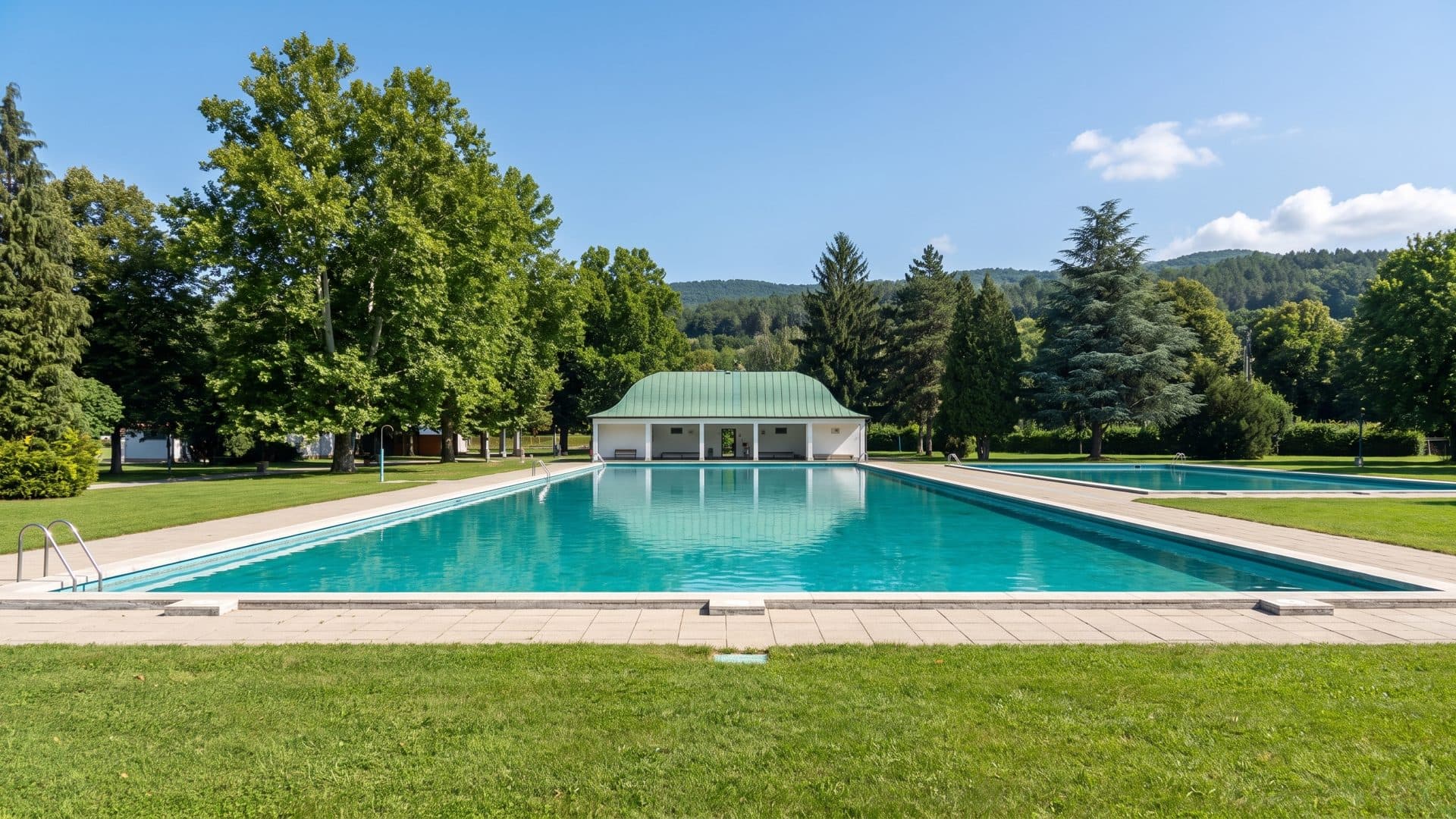 The outdoor pools of the Sellye thermal baths in front of their green-roofed pavilion