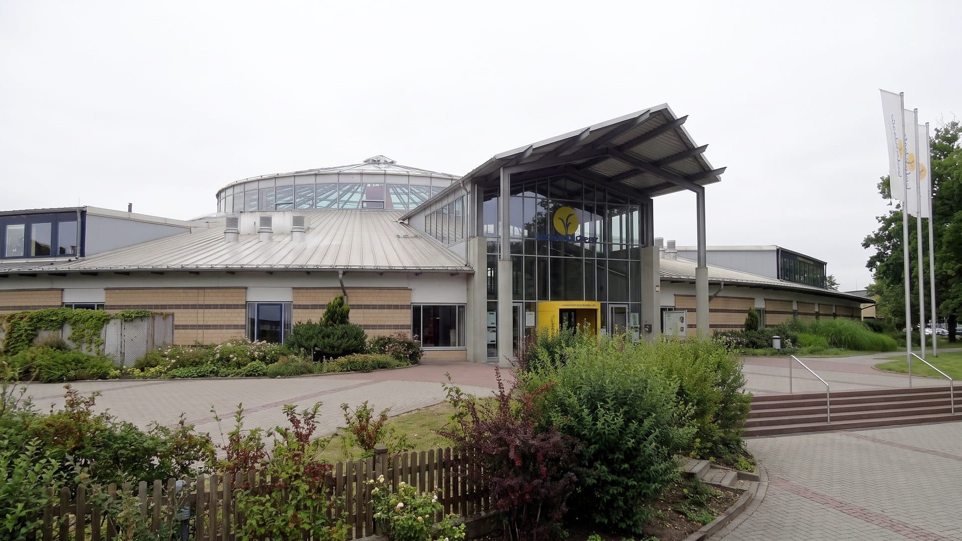 The entrance front of the Bulabana sport and leisure baths with its canopy and flagpoles