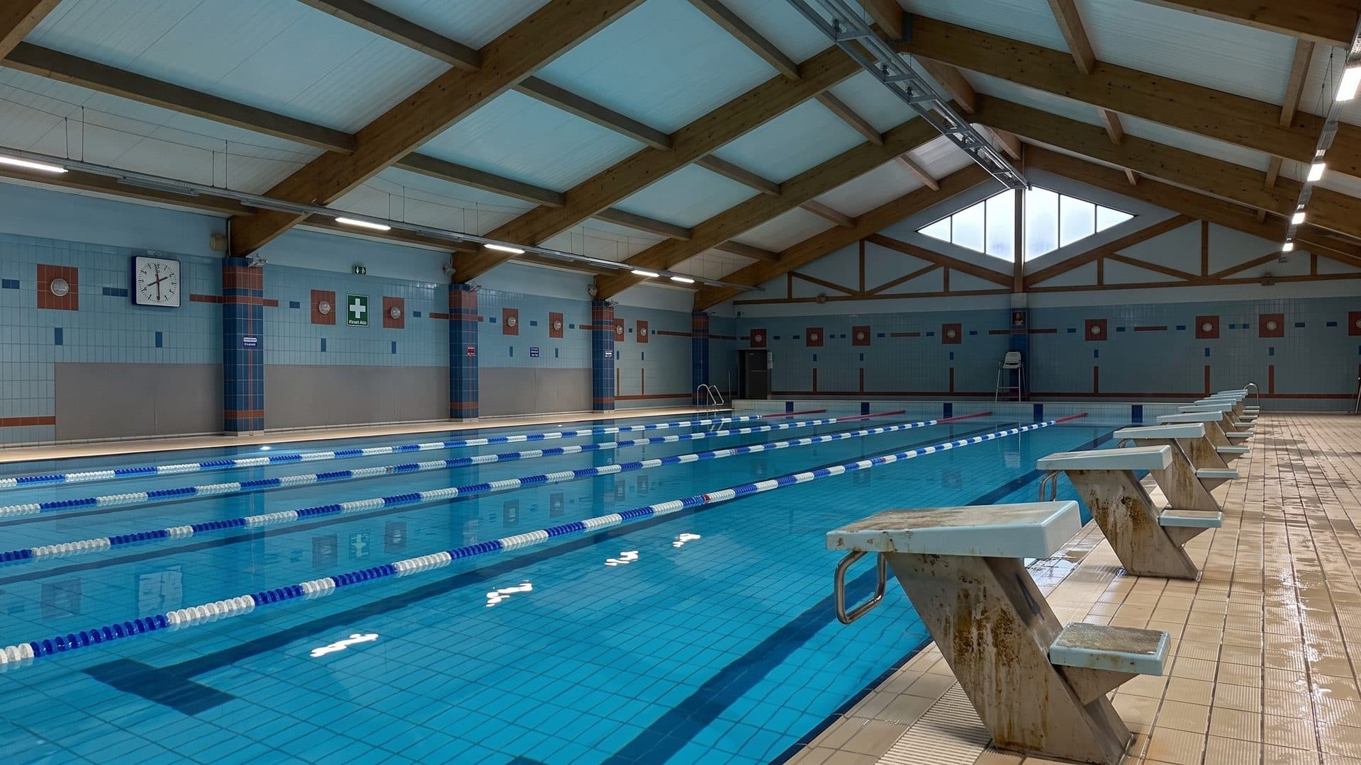 The lane pool of the Stacja Nowa Gdynia aquapark in Zgierz with starting blocks under a timber-trussed roof