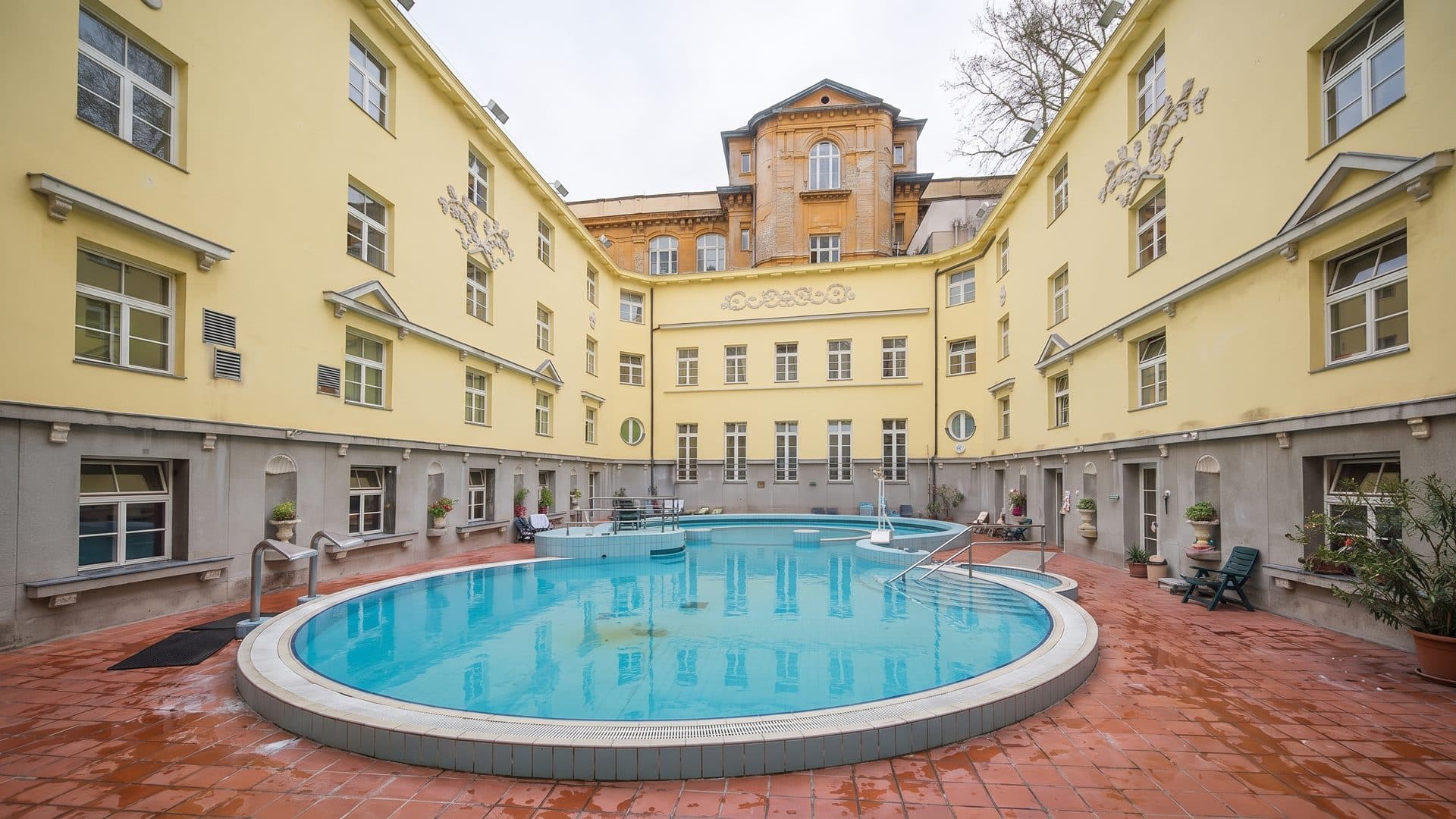 The courtyard pools of the Lukacs Baths in Budapest, enclosed by the yellow wings of the building