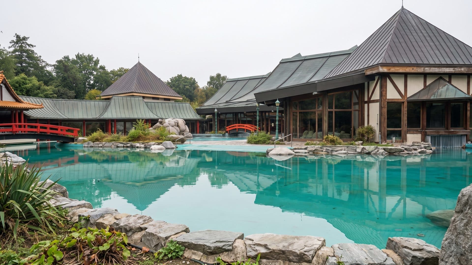 The lagoon pool at the Taunus Therme seen across the water, with the pagoda-roofed bath halls and rock edging behind it