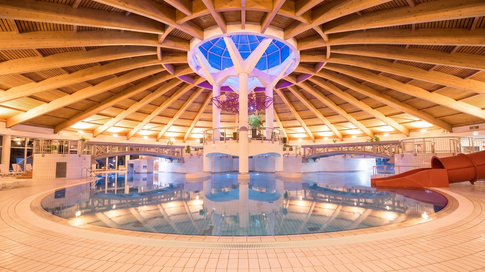 The leisure pool of the Tauris baths under the lit centre of its timber dome