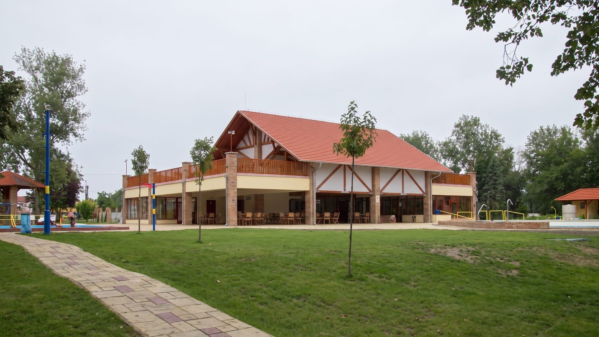 The red-roofed bath building of Termaldomb seen across its lawn