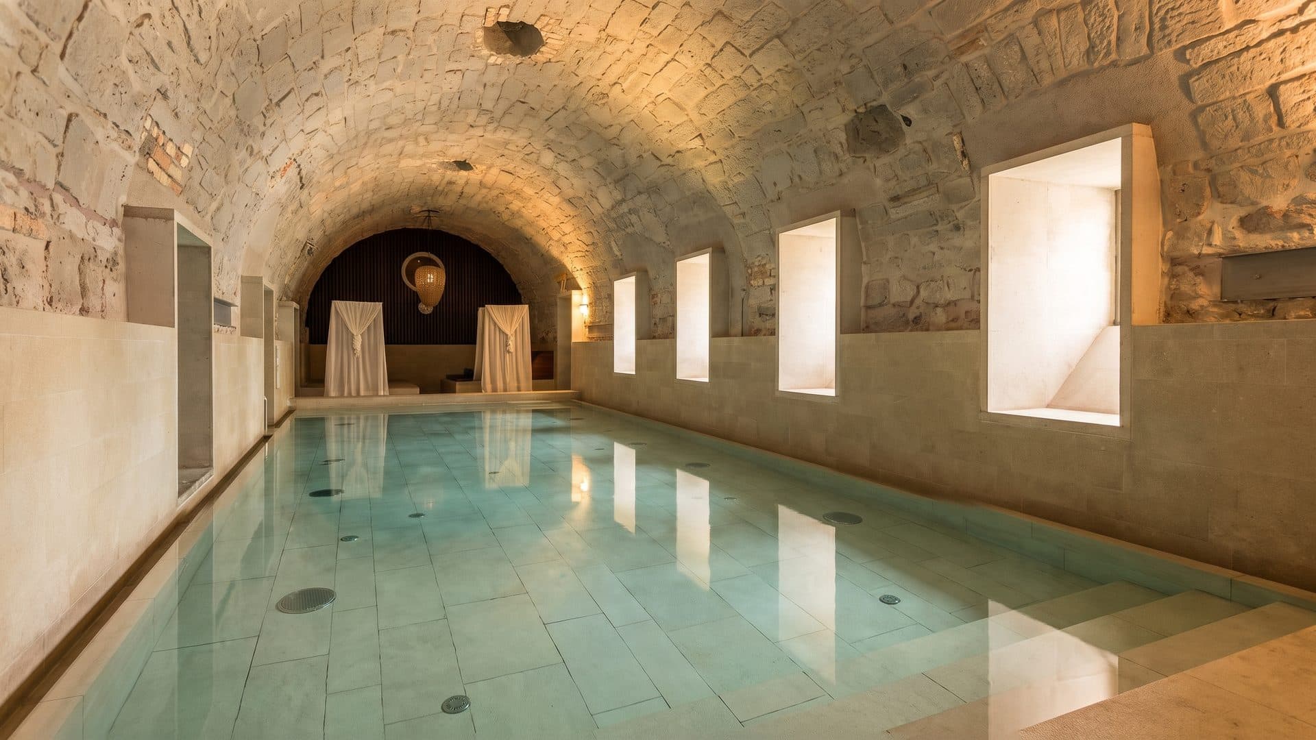 The vaulted stone bath of the Termali Salini with its arched niches along the water
