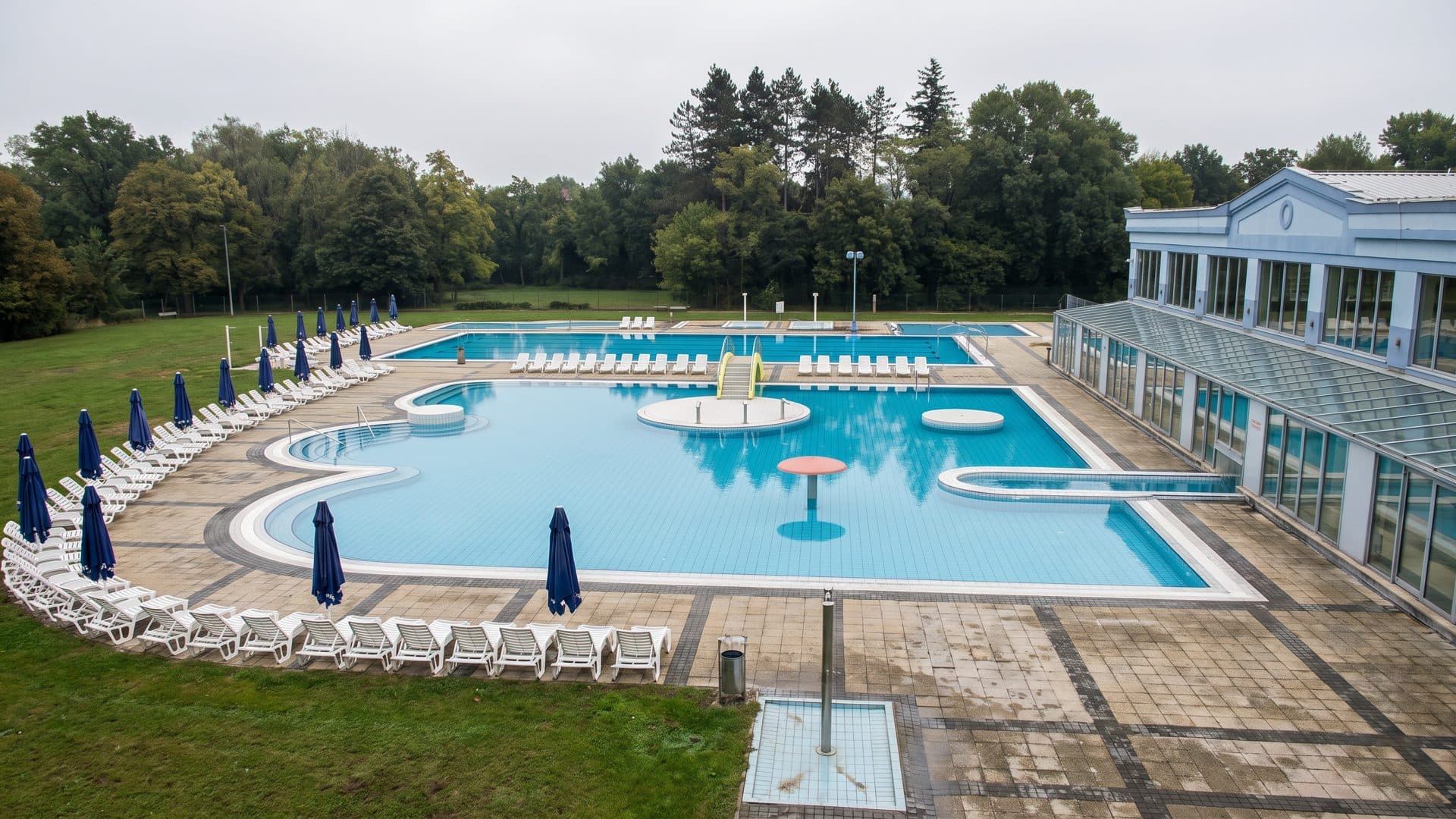 The open-air pools of the Aquae Balissae thermal water park in Daruvar, with the glazed pavilion along one side.