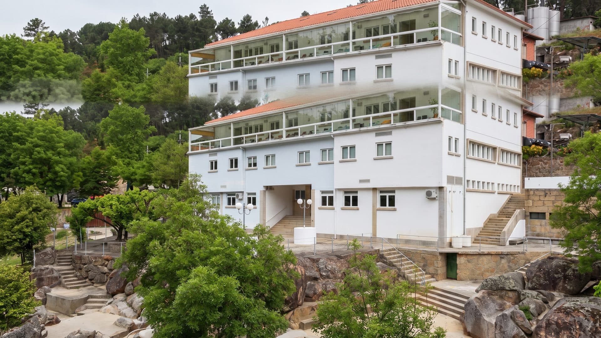 The white spa building of Alcafache on its terraced slope among the trees