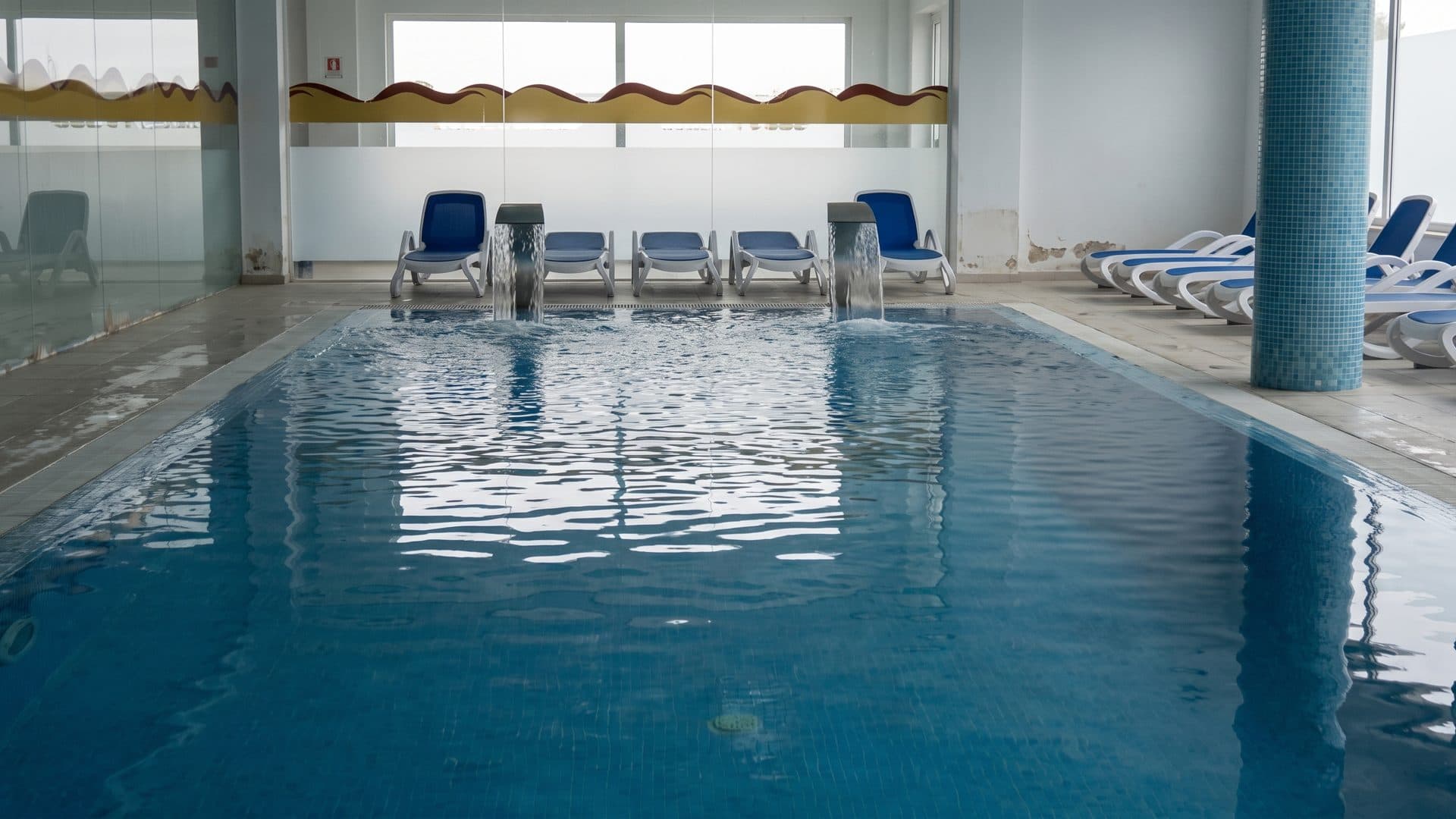 The thermal pool at Termas do Bicanho, its row of jets and loungers along the water