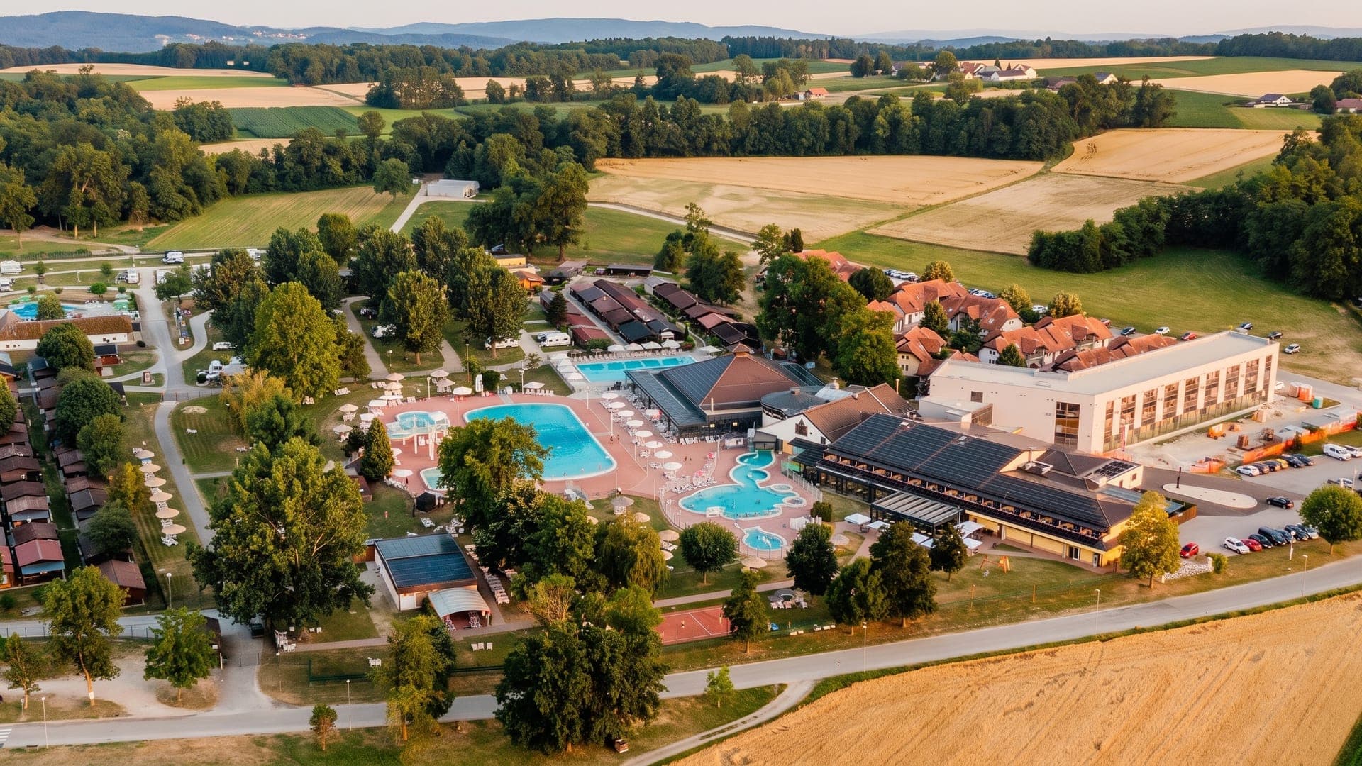 Aerial view of the outdoor pools and lodges among fields
