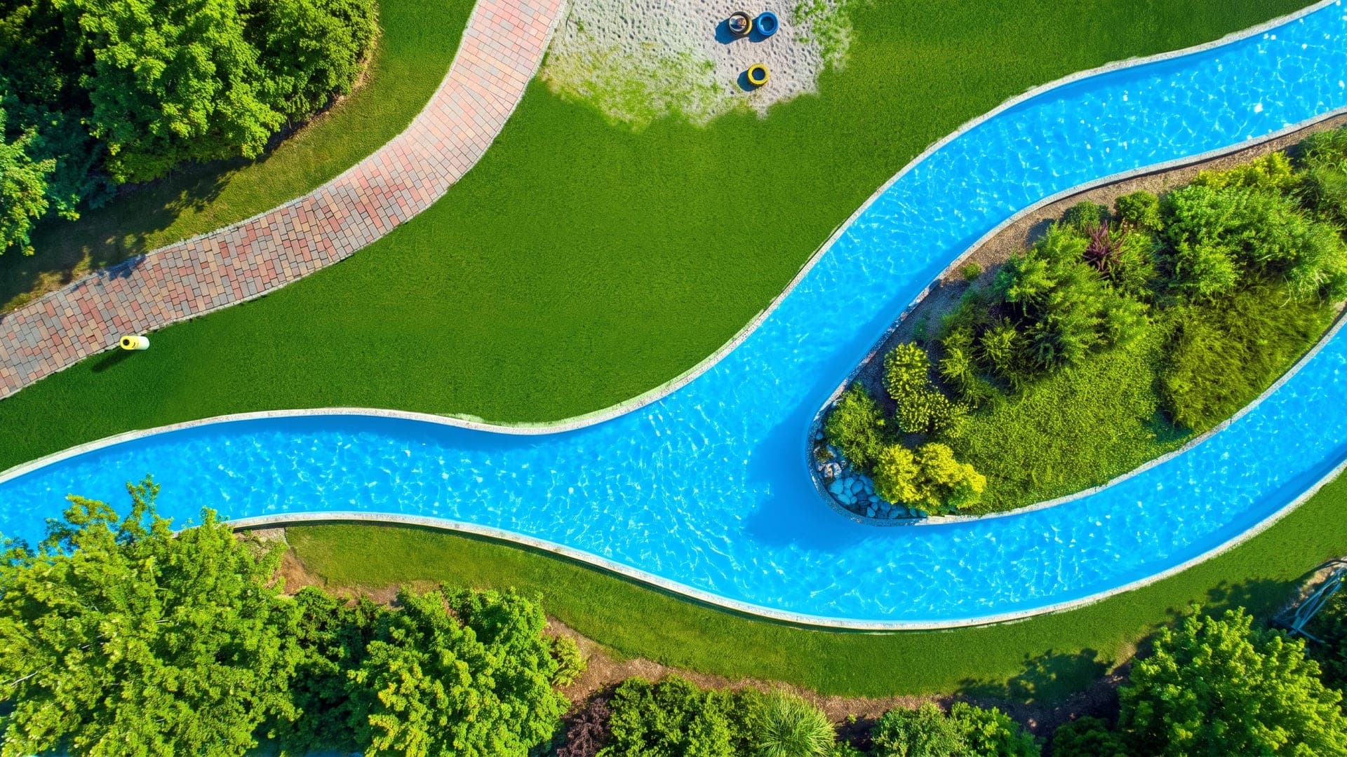Winding lazy-river pool through the lawns, seen from above