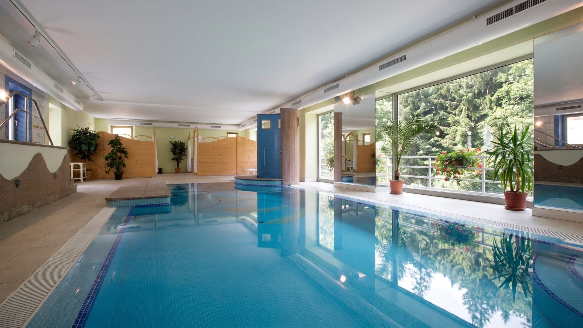 The pool of Terme di Rabbi along its glazed wall under the hall ceiling