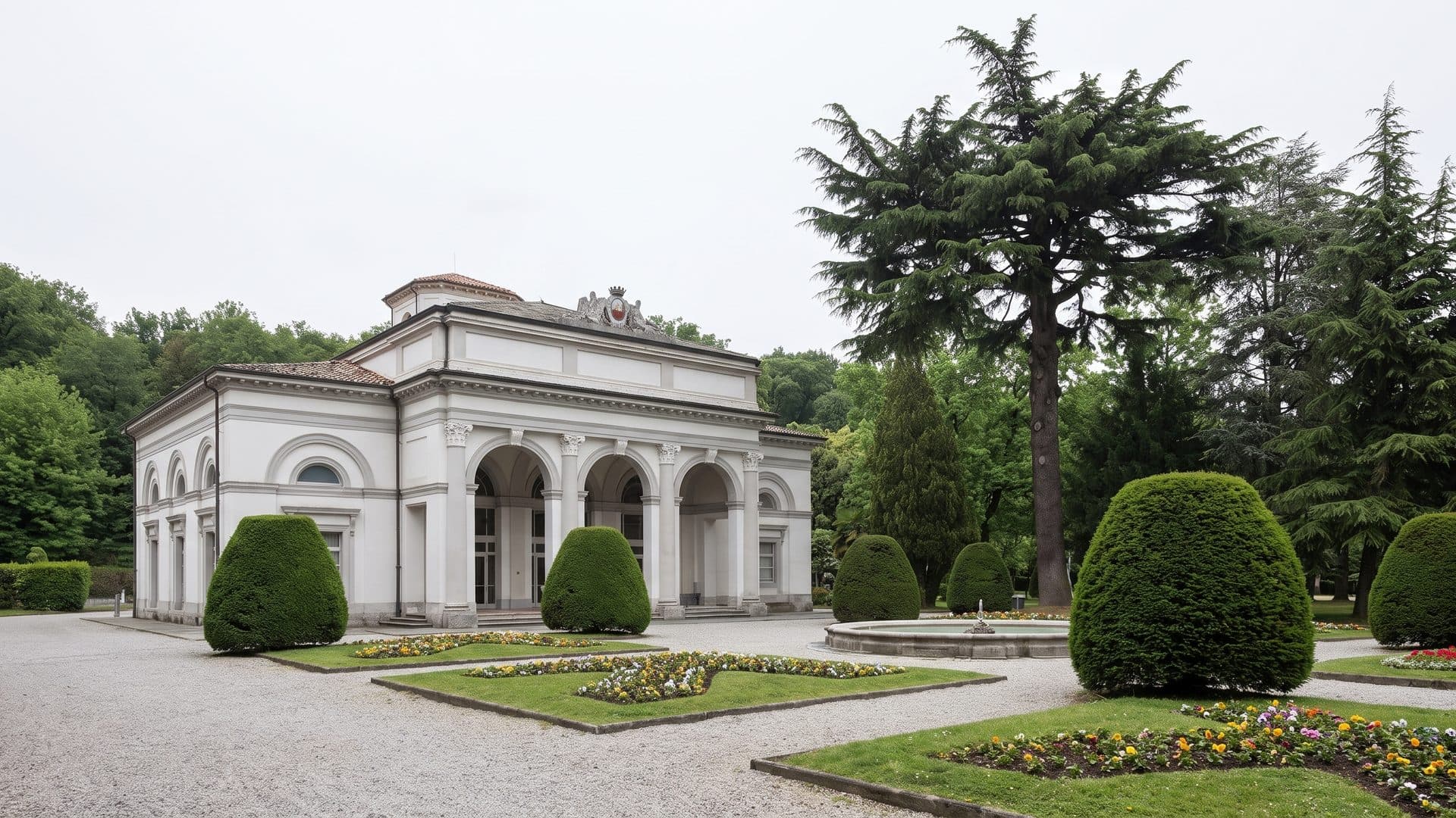 The historic bath pavilion of Terme di Riolo among clipped hedges and tall cedars