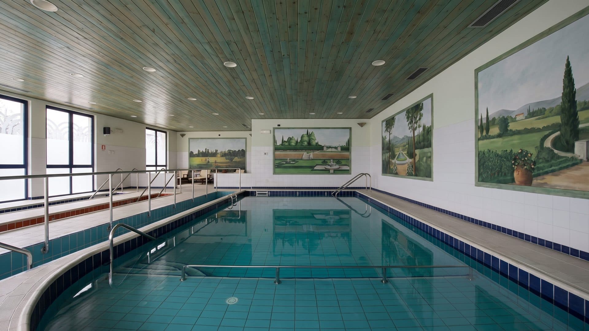 The indoor pool at Terme Respighi in Tabiano, with painted landscape panels along the wall