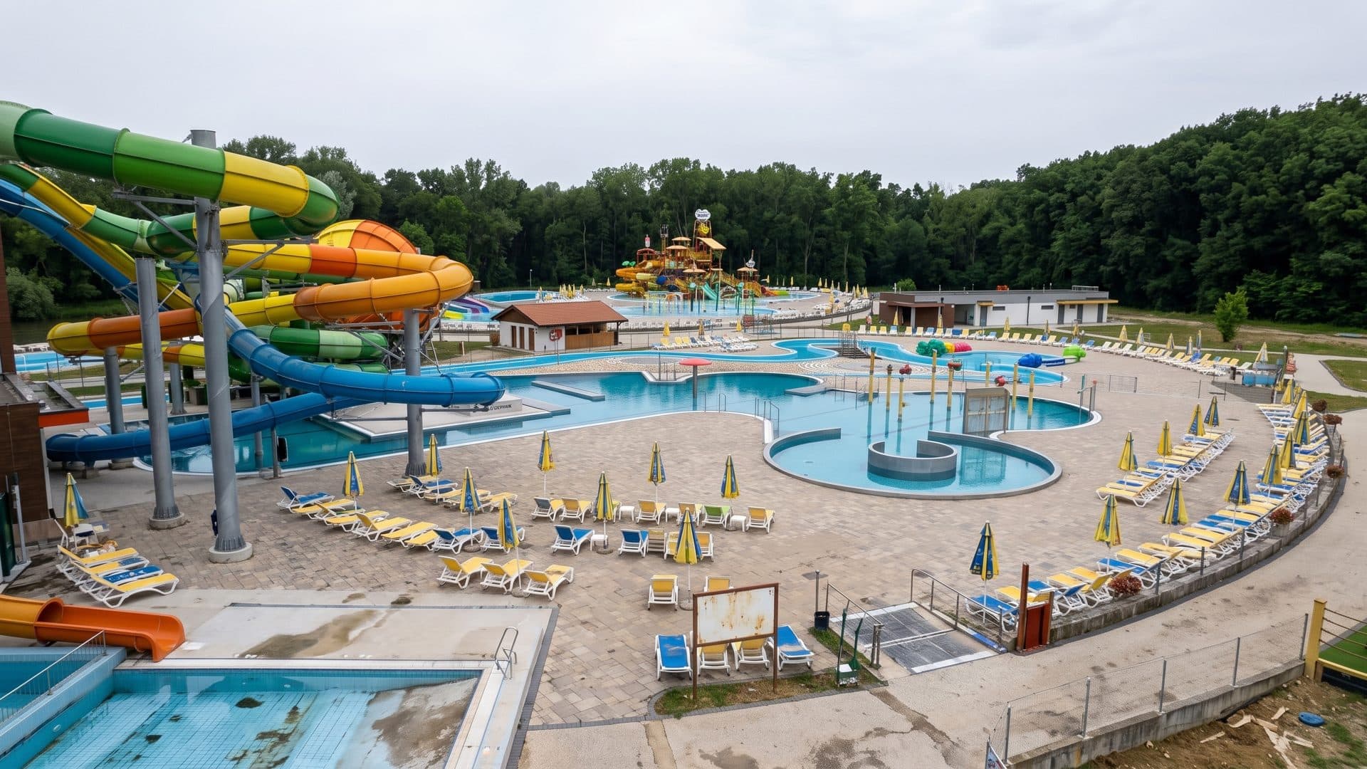 Thermal park from above: slides, a chain of pools and parasols along the paved terraces.