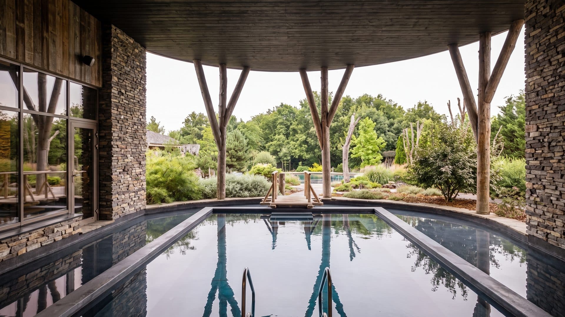 The outdoor pool of Thermen Katara with its stone and timber surround among the trees