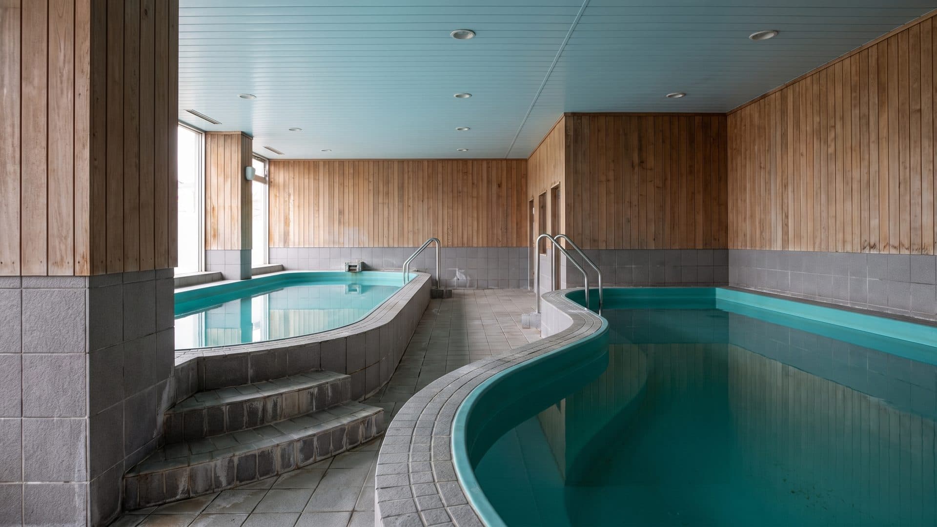 An indoor thermal pool at Thermes de Brides-les-Bains, with tiled steps down into the water.