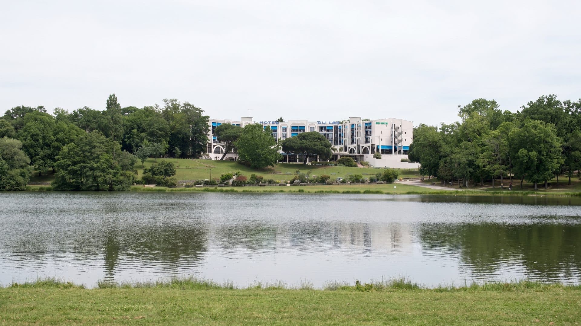 The Christus thermal buildings seen across the lake among their trees