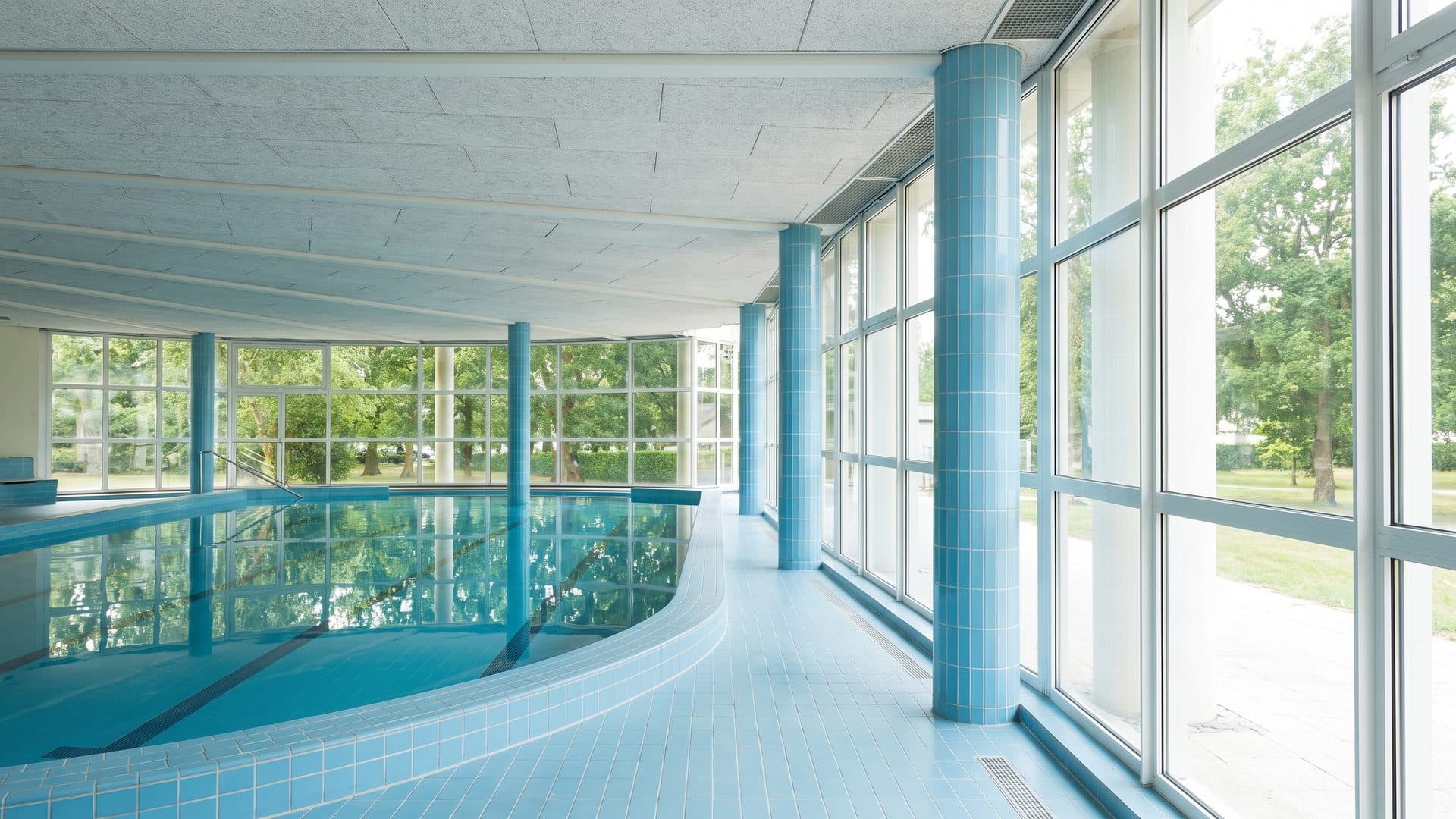 The glazed pool hall of the Thermes des Chenes with daylight along the tall windows