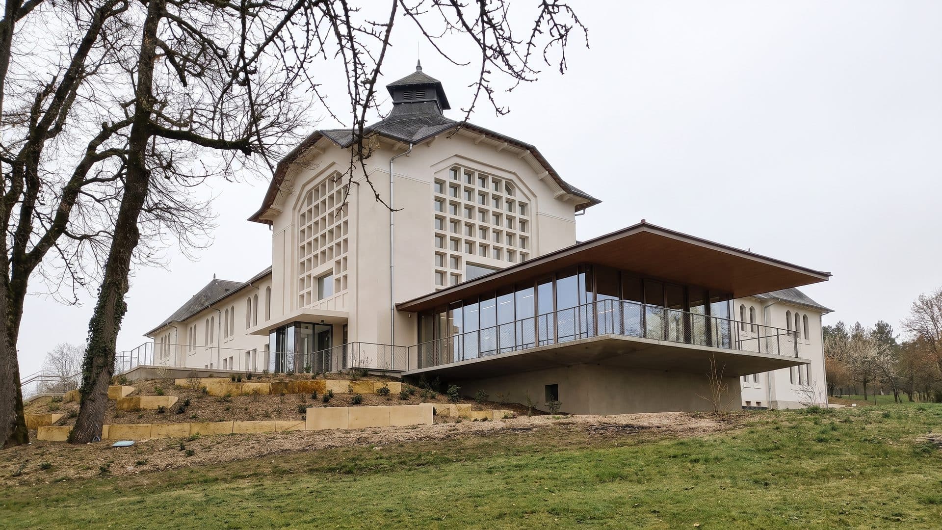 The spa building of the Thermes du Connetable seen three-quarters on among its trees
