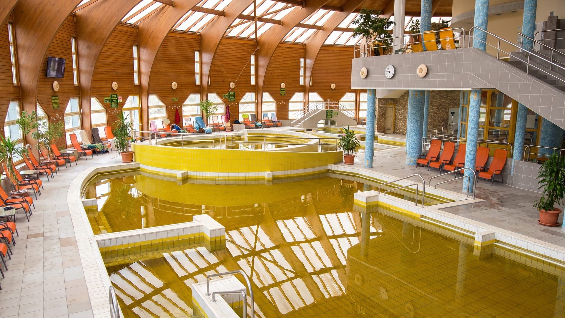 The indoor hall at Tiszaujvarosi Gyogy- es Strandfurdo, its amber mineral water under a timber vaulted roof.