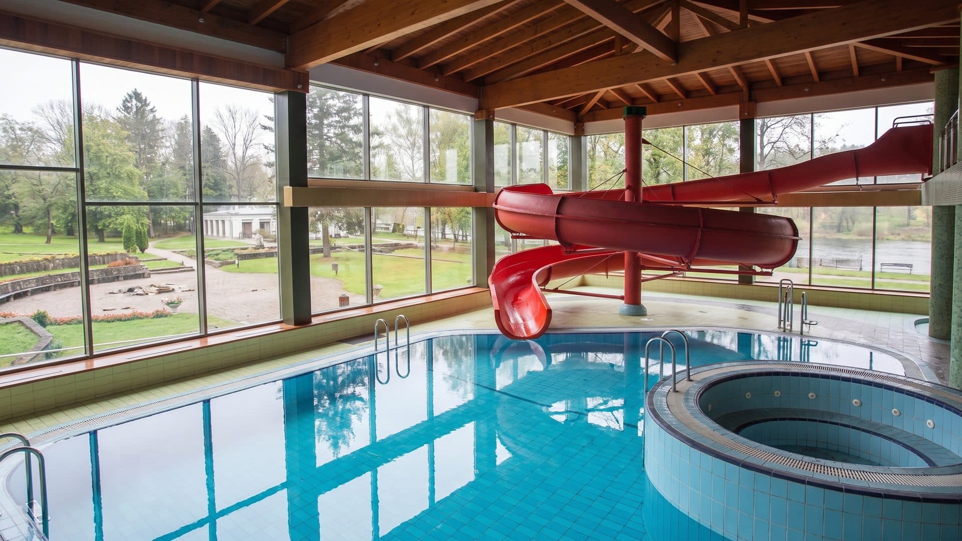 The indoor pool at the Tulpe sanatorium in Birstonas, with its red water slide beside the glazed wall