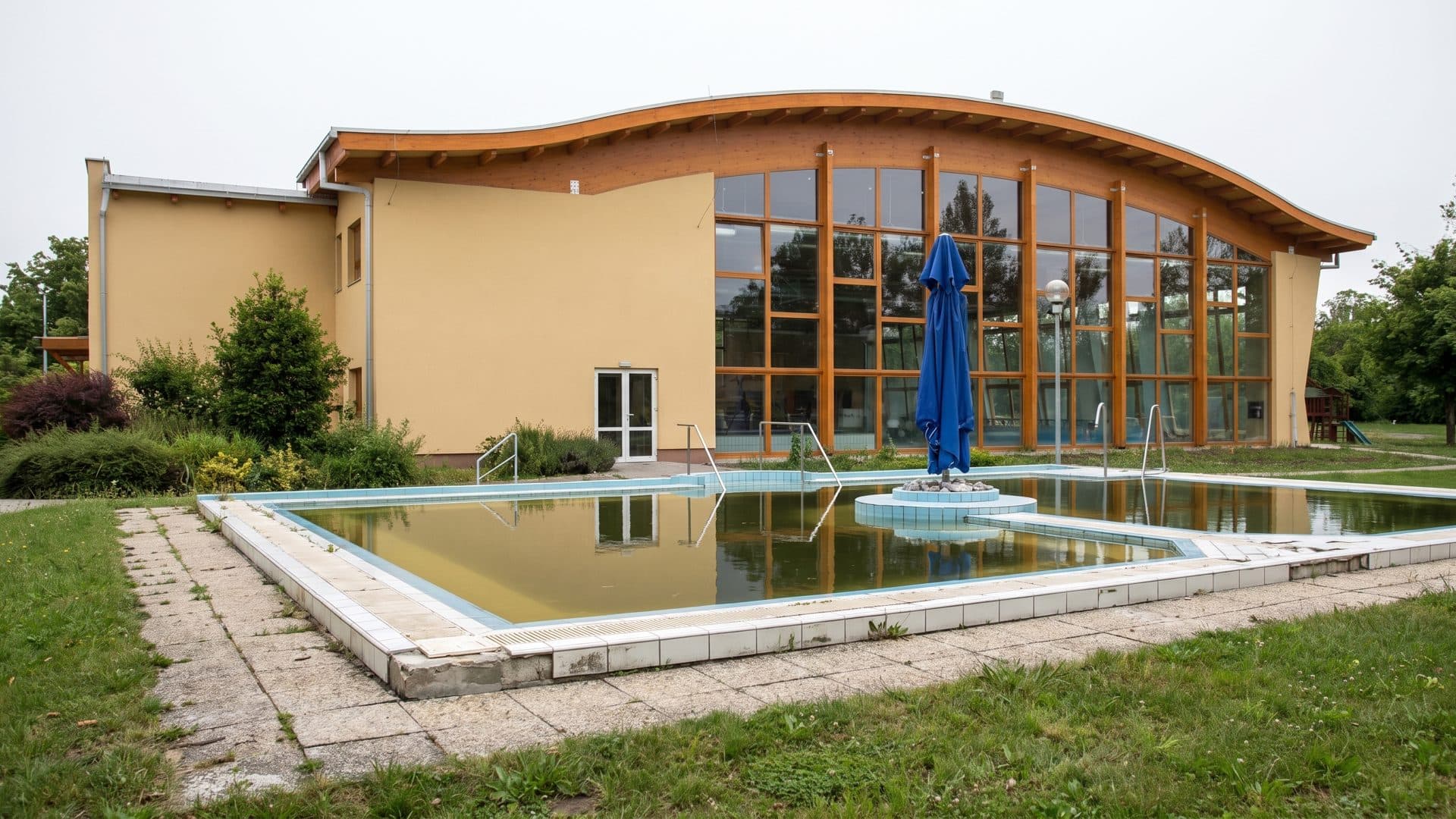 The outdoor thermal pool at Turkeve in front of the curved timber bath building
