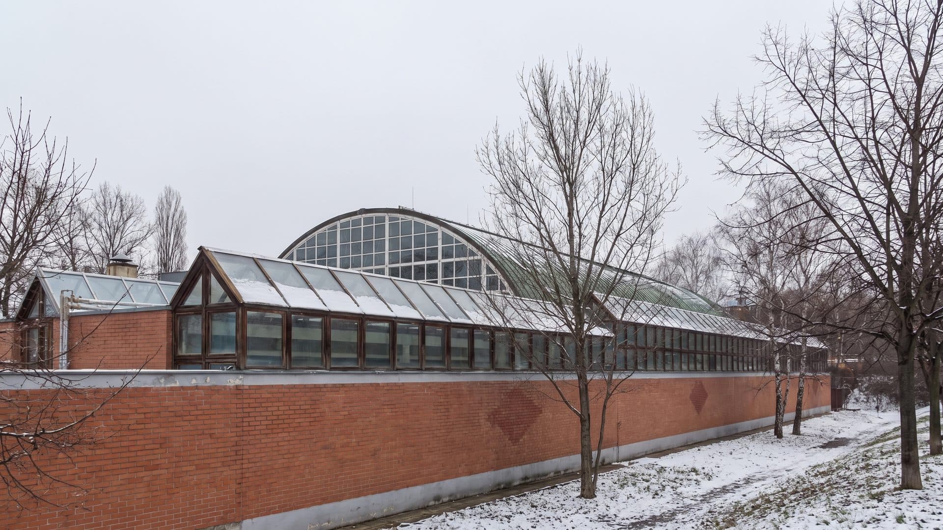 The brick hall of the Újhegy baths with its glazed vault among the bare winter trees