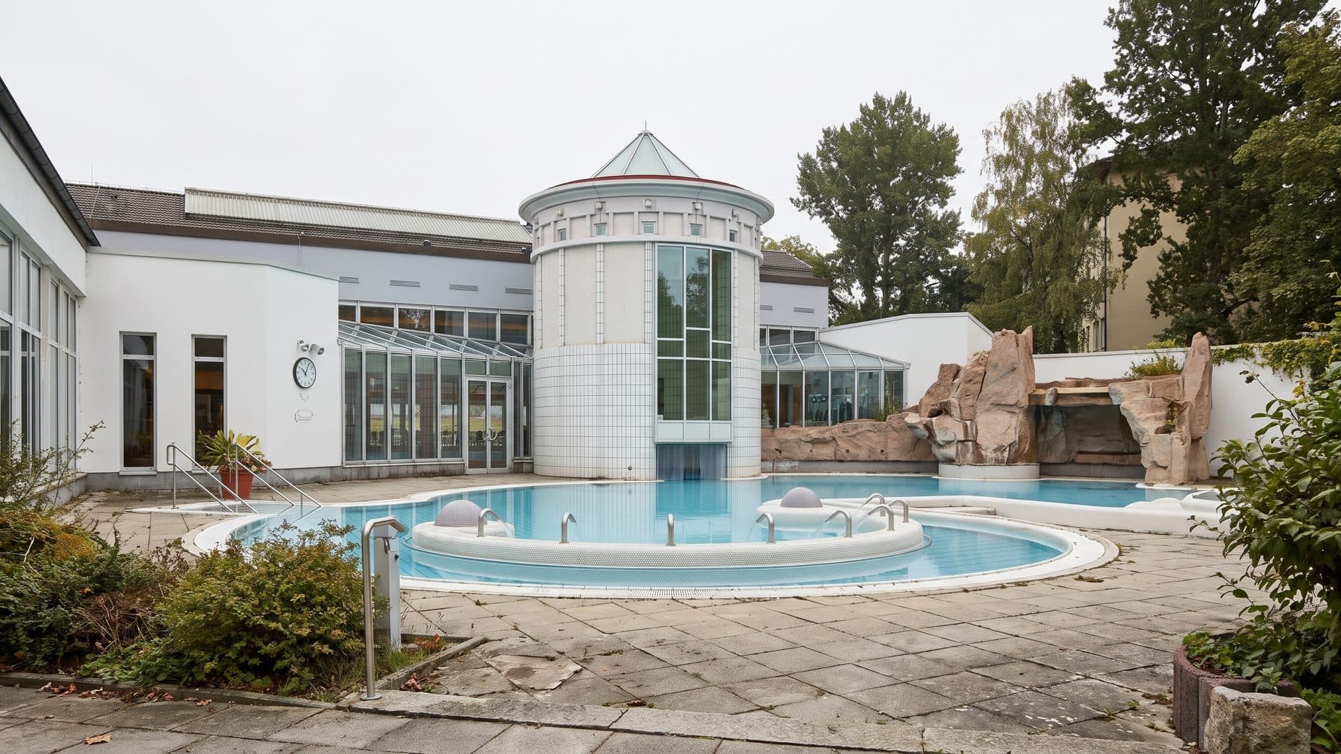 The round outdoor pool at the Vita Classica Therme, with the glazed tower and the water slide behind it