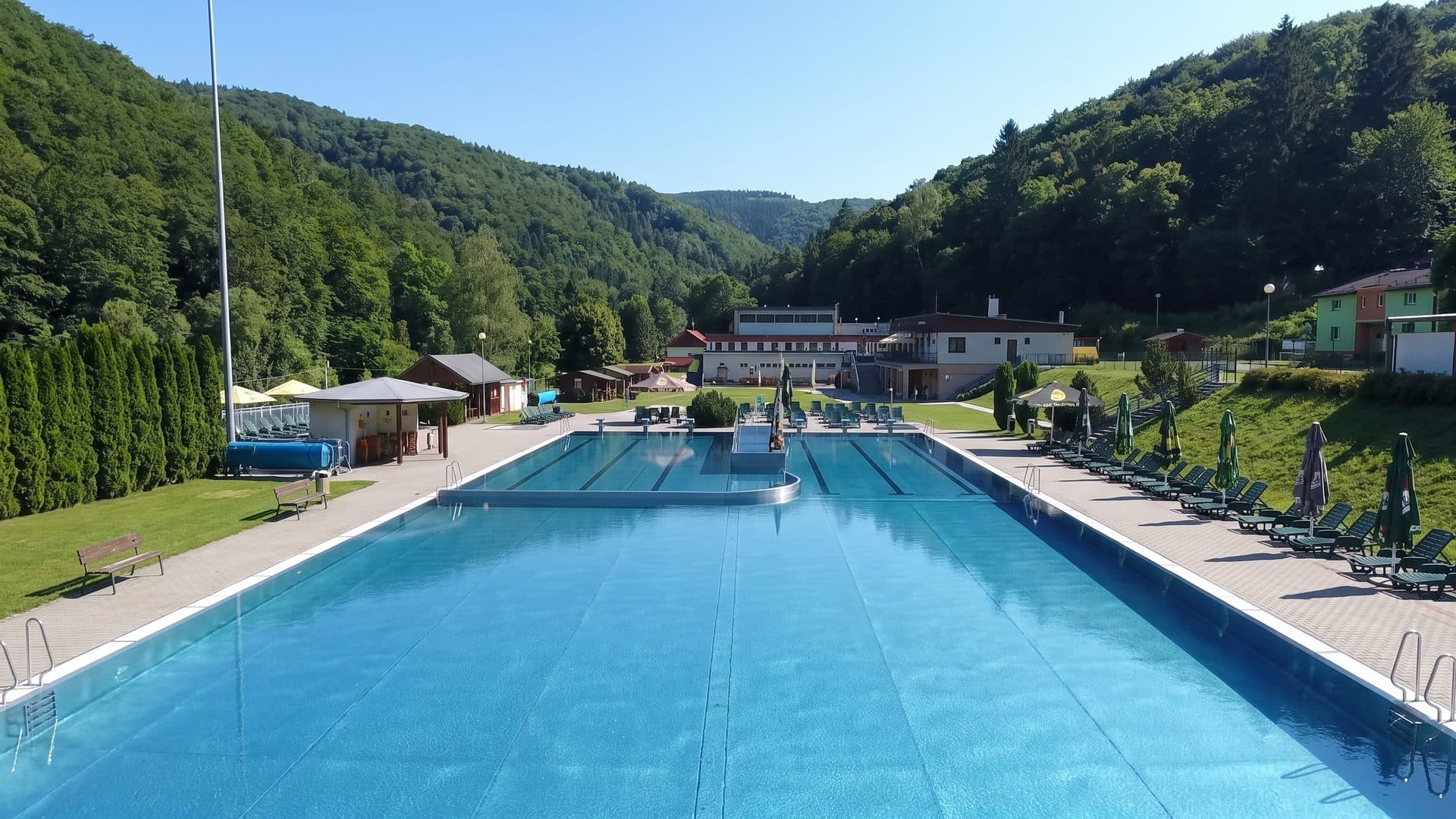 The outdoor pools of Vodny Raj Vyhne with the wooded valley sides behind