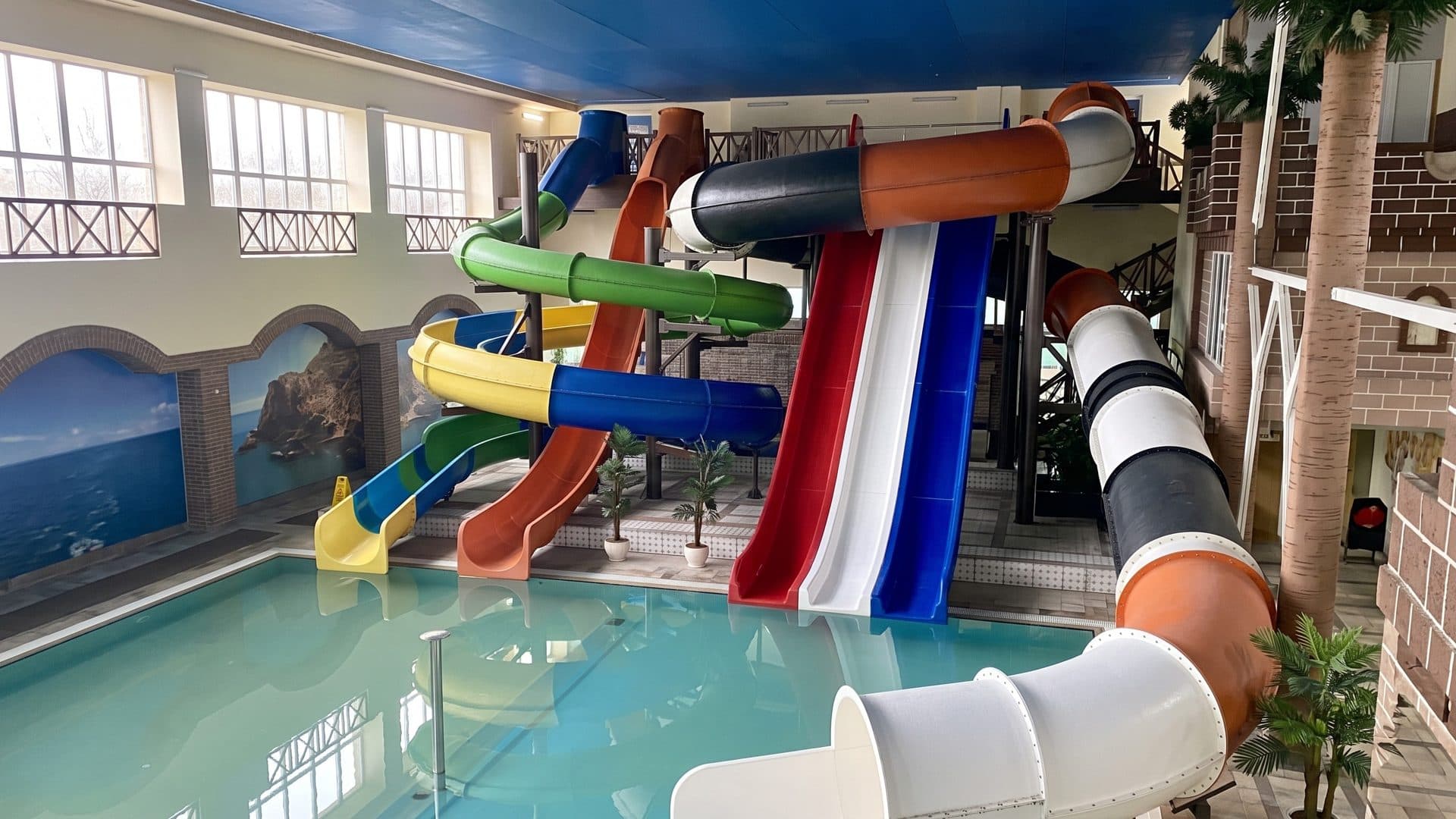A cluster of coloured slides above the indoor pool of Water Land in Bukharovo