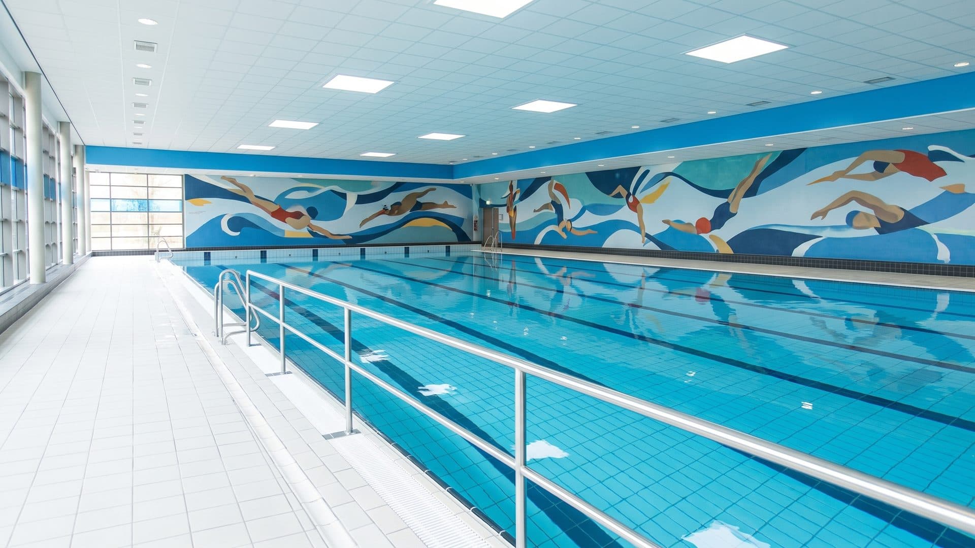 The pool of the Wesavi baths in front of the painted swimmers on its end wall